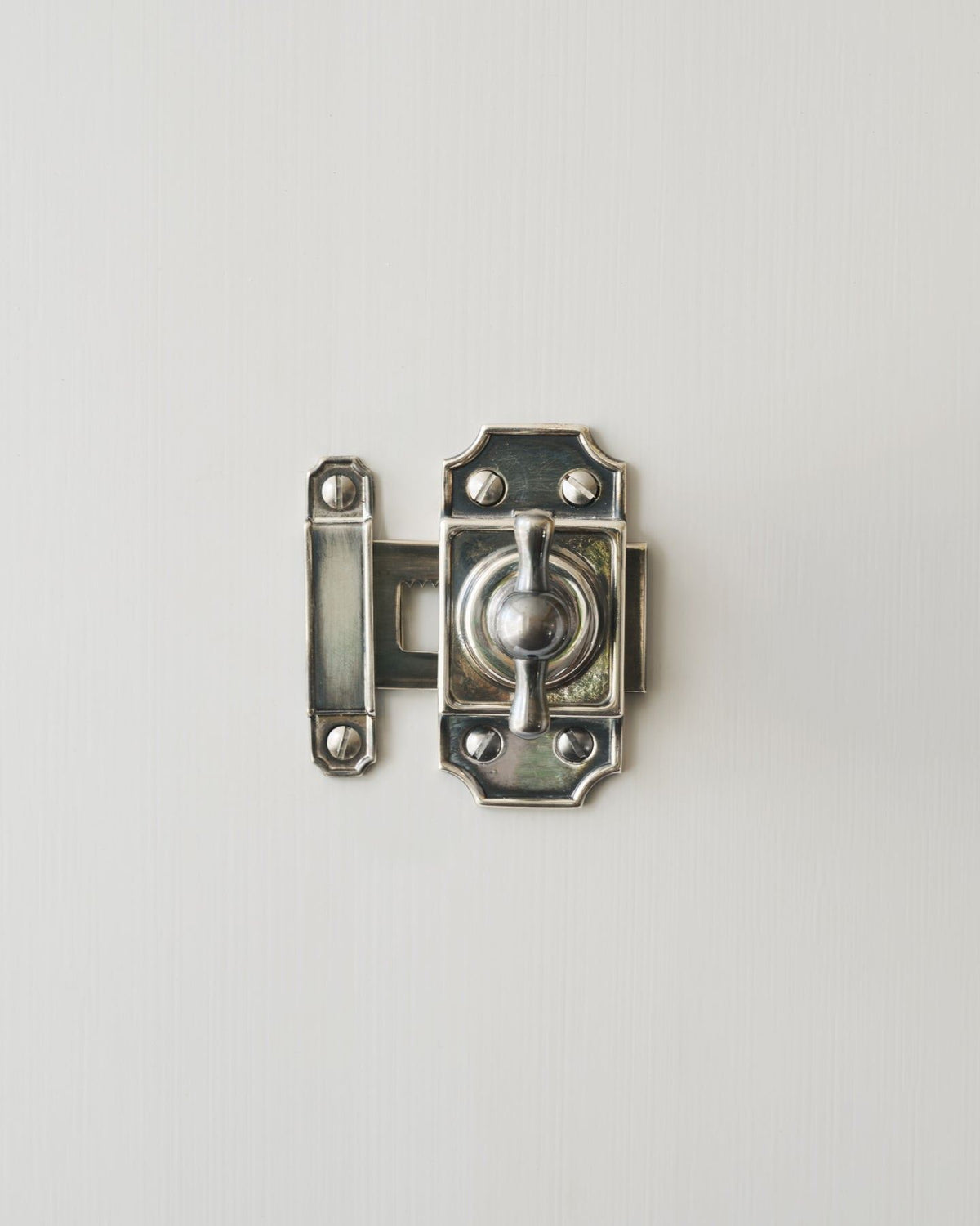 A Victorian-inspired rack and pinion cupboard catch in a tarnished silver finish. TEST