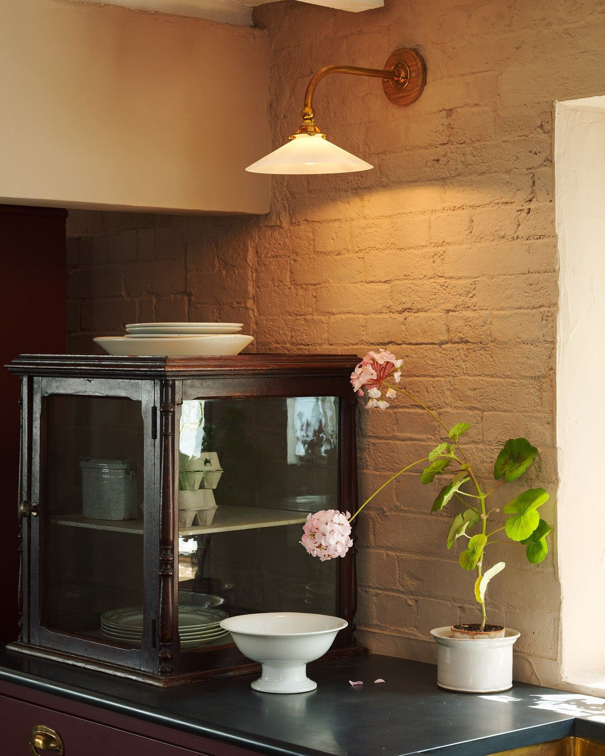 A close-up view of a decorative brass gallery and light fitting attached to a milk glass light shade. TEST