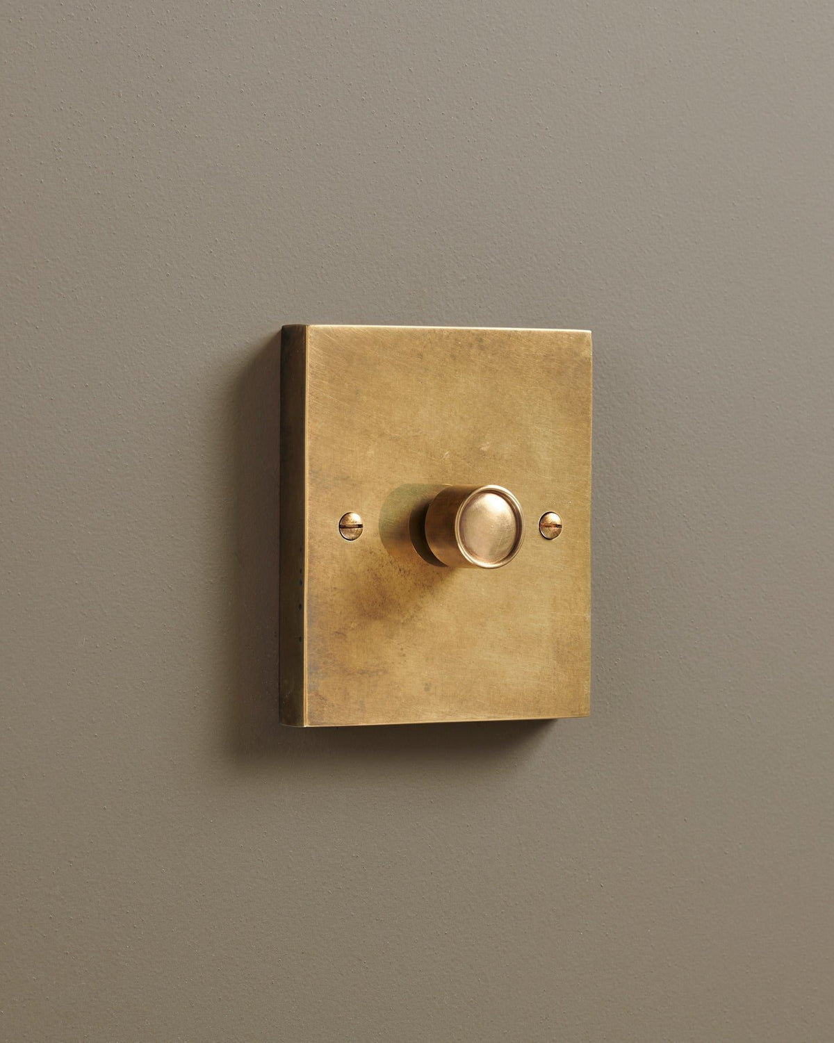 An oblique view of a 1 gang box dimmer switch in a warm burnished brass finish. TEST