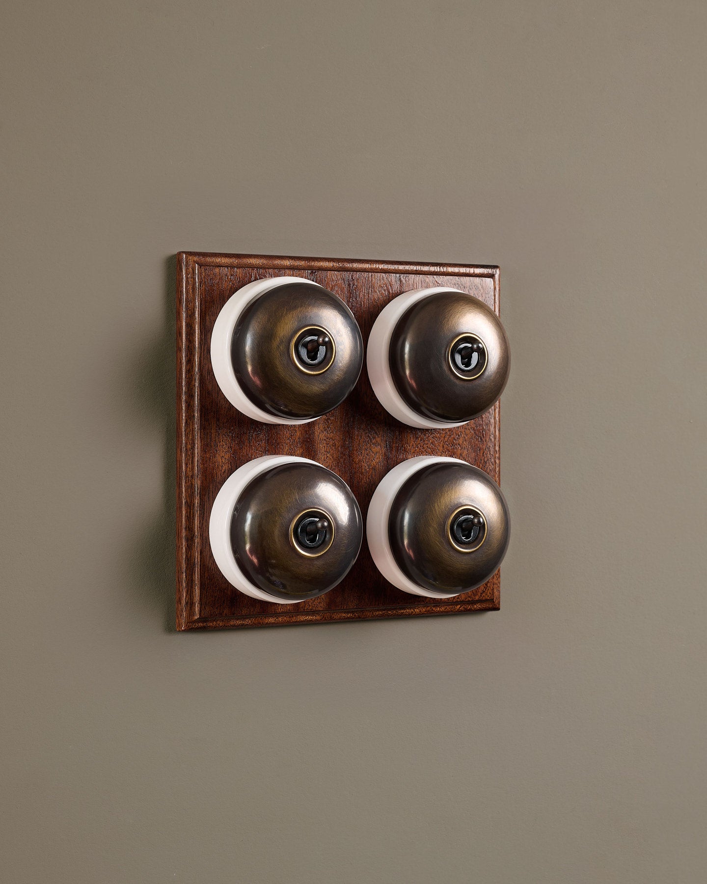 The Dolly Toggle Switch (4 Gang Bank & Mahogany Finish Pattress) - Oxidised Brass with White Base.
