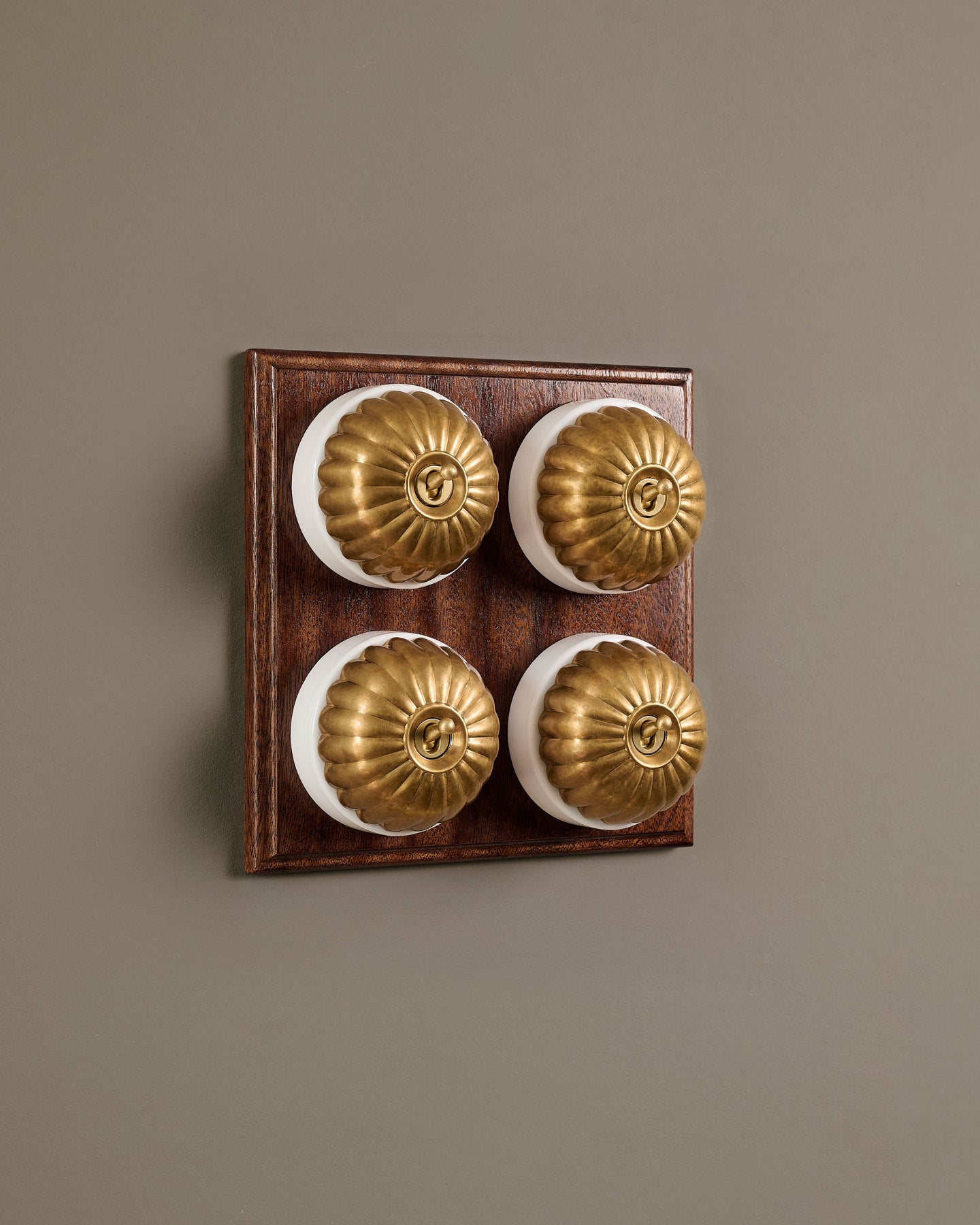 The Jelly Toggle Switch (4 Gang Bank & Mahogany Finish Pattress) - Aged Brass with White Base.