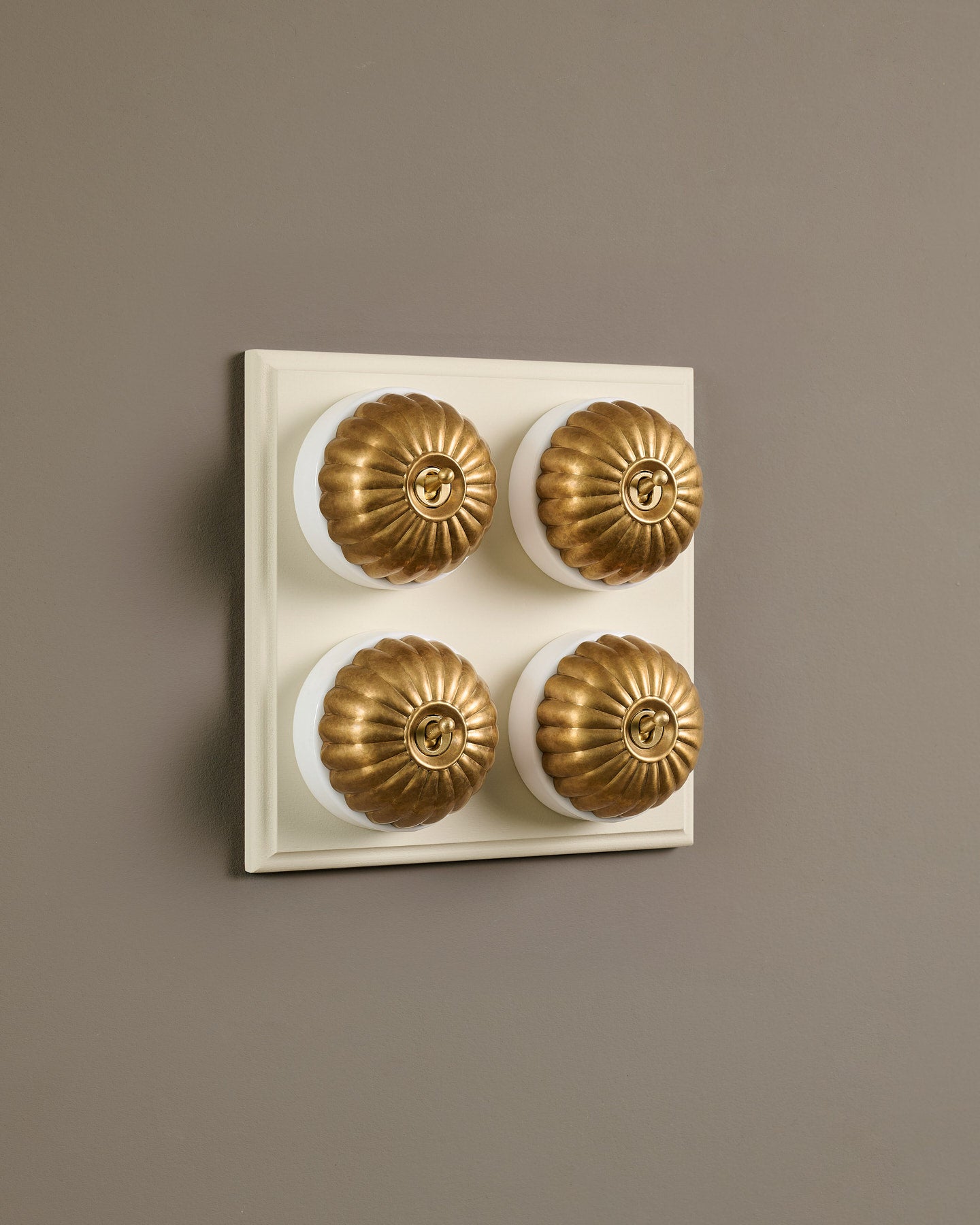 The Jelly Toggle Switch (4 Gang Bank & Primed Maple Pattress) - Aged Brass with White Base.