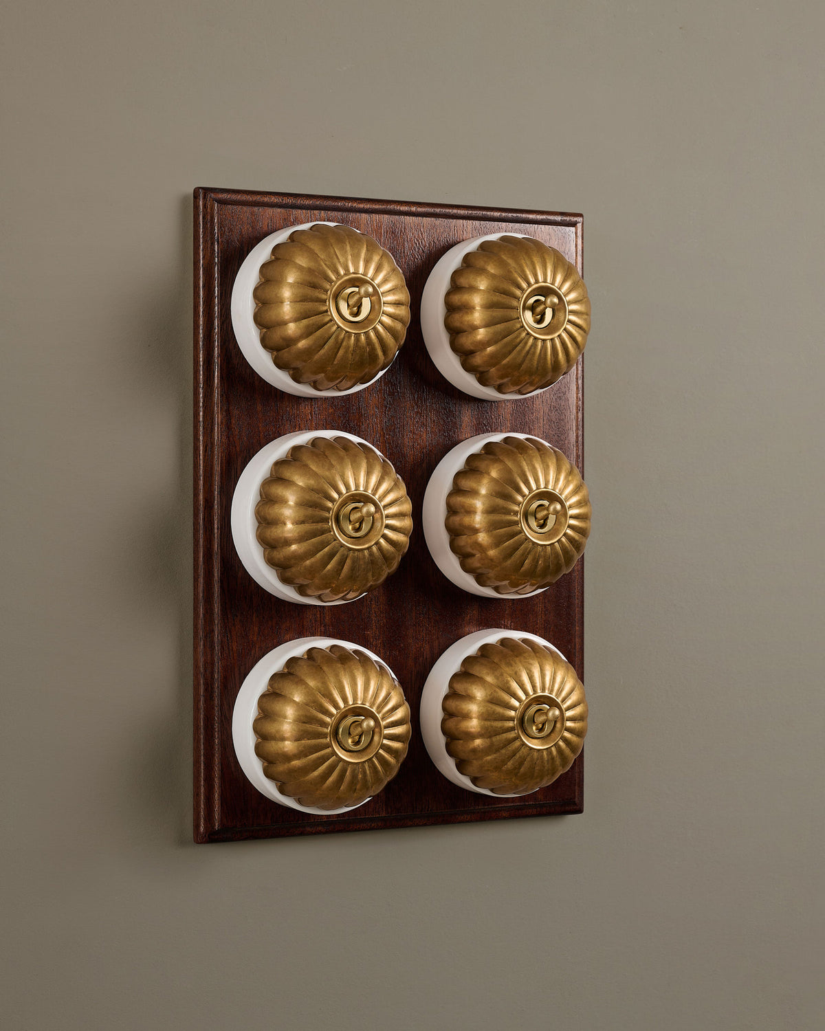 The Jelly Toggle Switch (6 Gang & Mahogany Finish Pattress) - Aged Brass with White Base. TEST