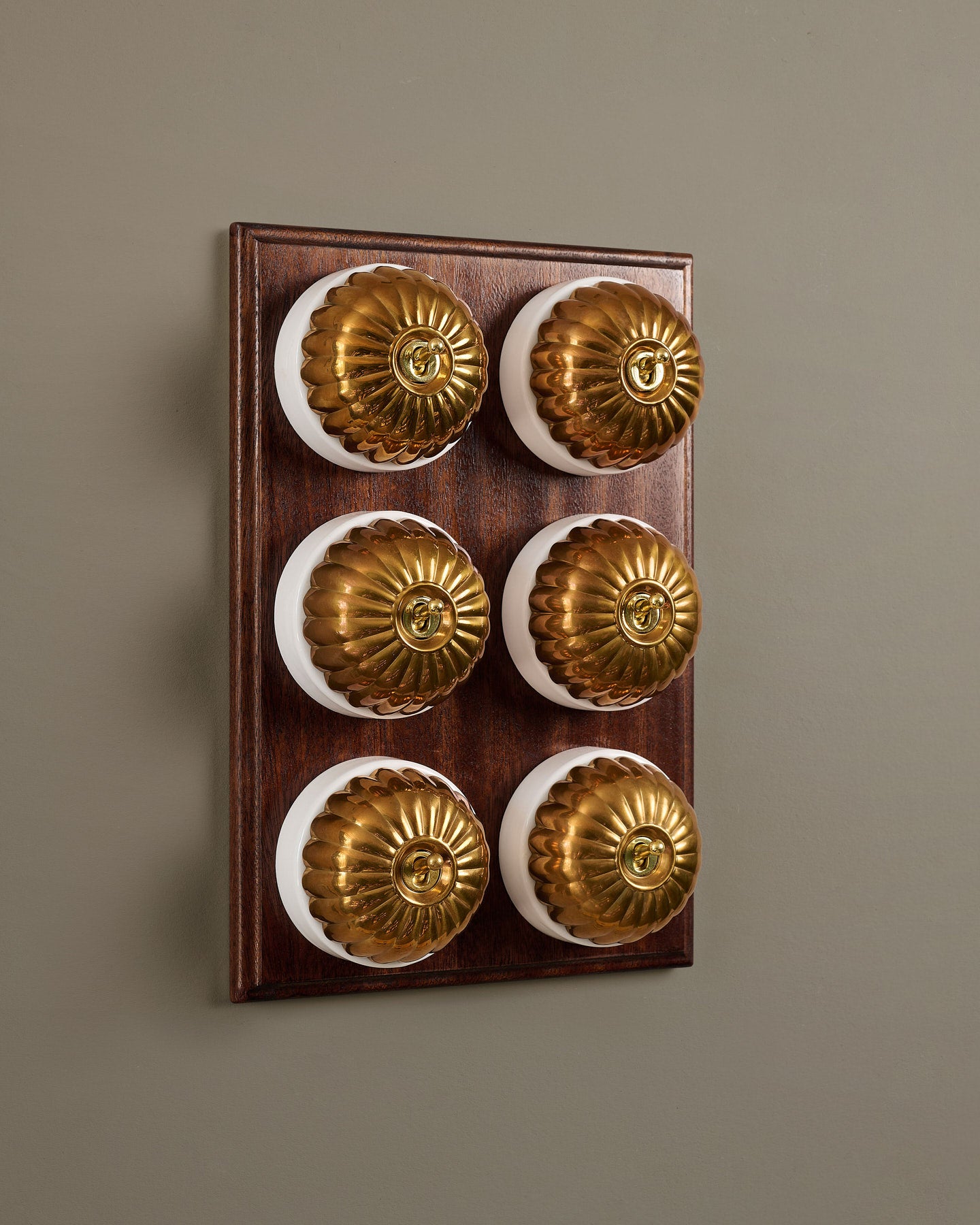 The Jelly Toggle Switch (6 Gang & Mahogany Finish Pattress) - Heirloom Brass with White Base.