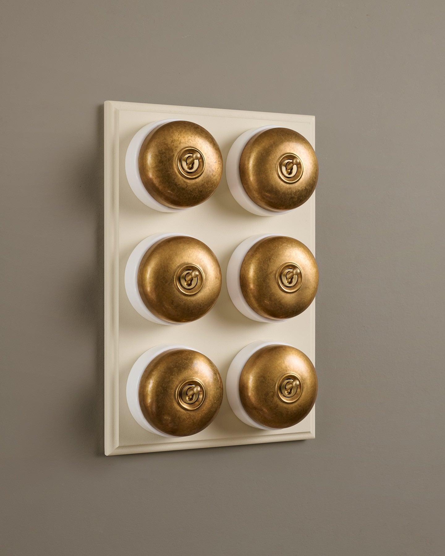 The Dolly Toggle Switch (6 Gang & Primed Maple Pattress) - Aged Brass with White Base.