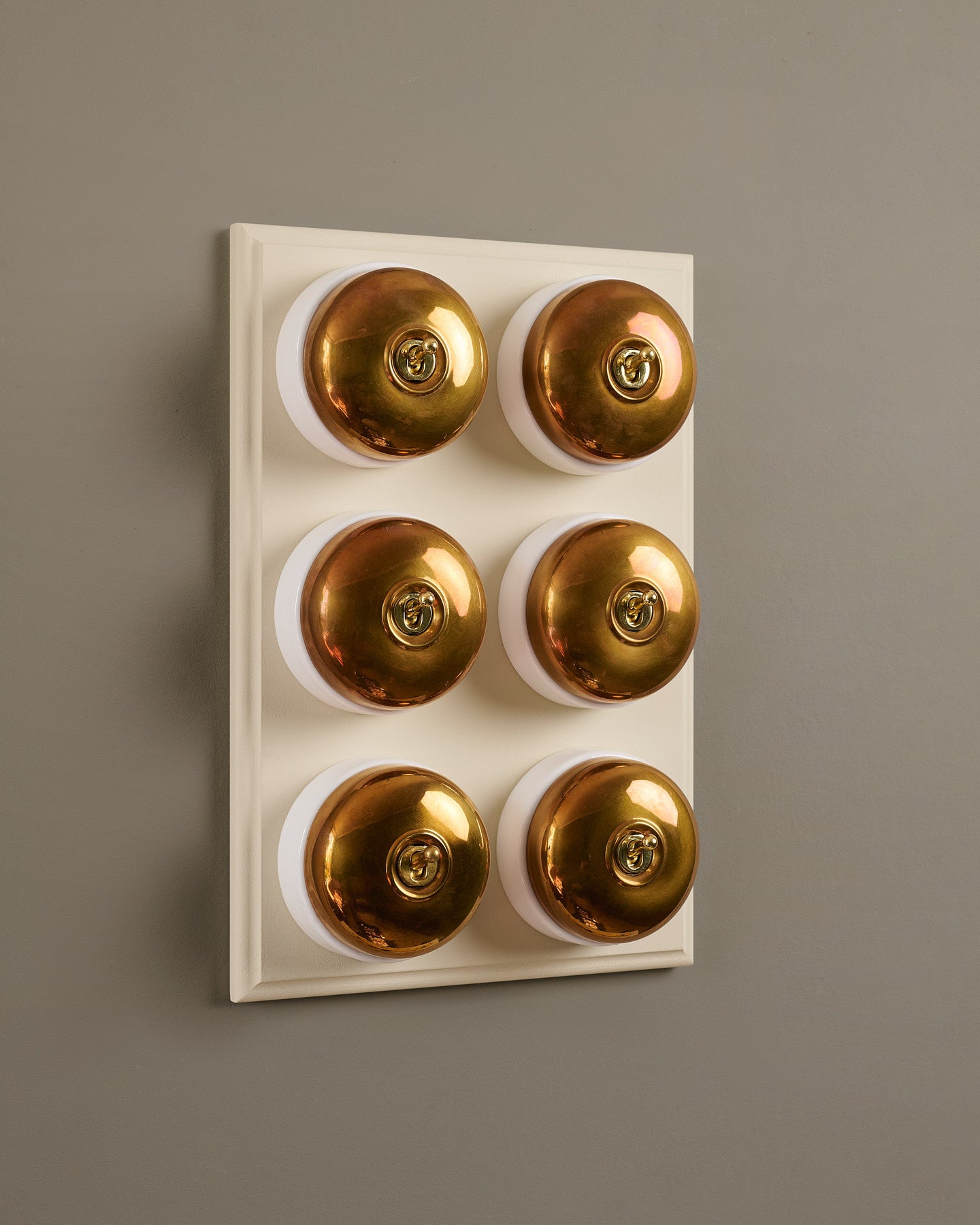 The Dolly Toggle Switch (6 Gang & Primed Maple Pattress) - Heirloom Brass with White Base.