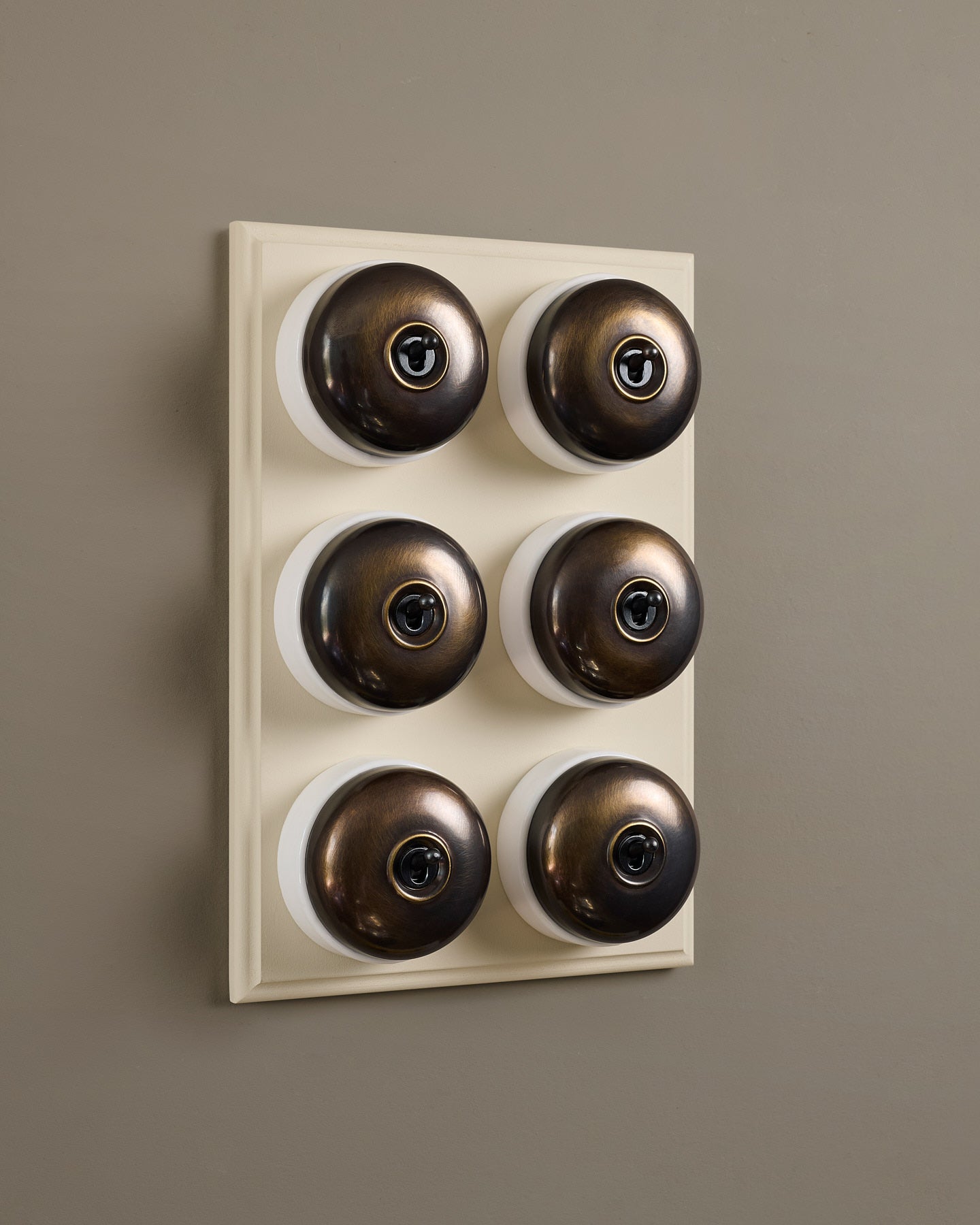 The Dolly Toggle Switch (6 Gang & Primed Maple Pattress) - Oxidised Brass with White Base.
