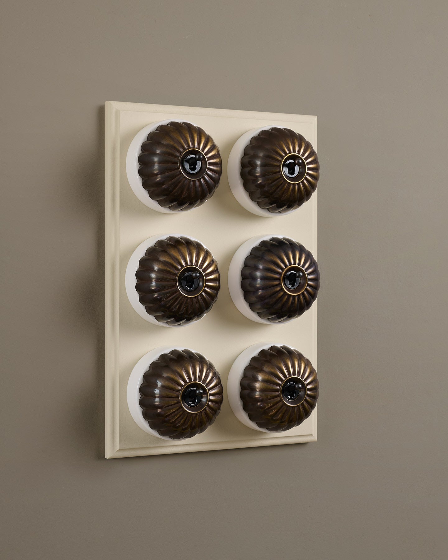 The Jelly Toggle Switch (6 Gang & Primed Maple Pattress) - Oxidised Brass with White Base.