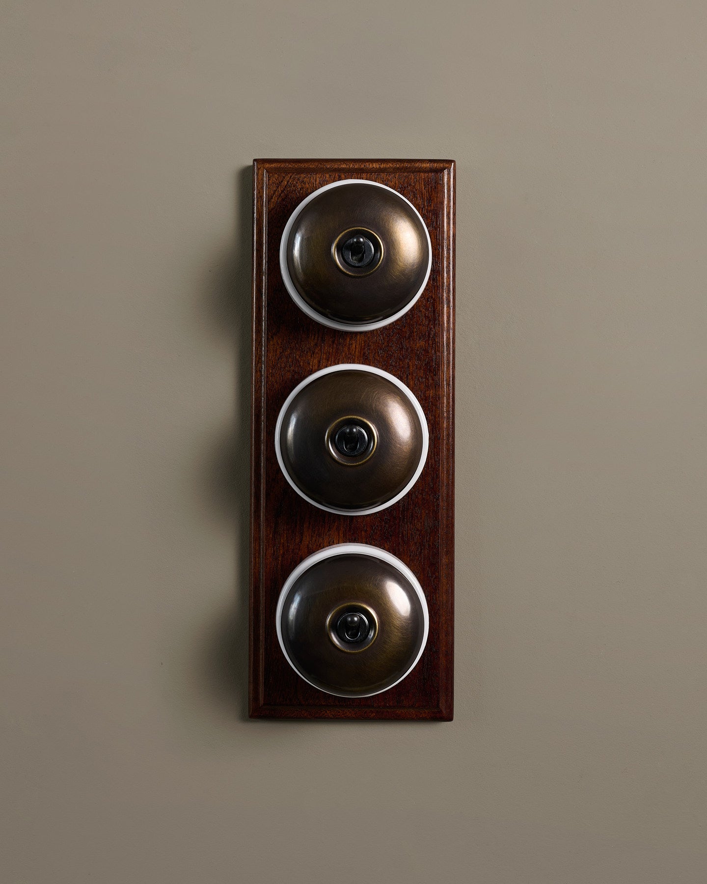 The Dolly Toggle Switch (3 Gang & Mahogany Finish Pattress) - Oxidised Brass with White Base.