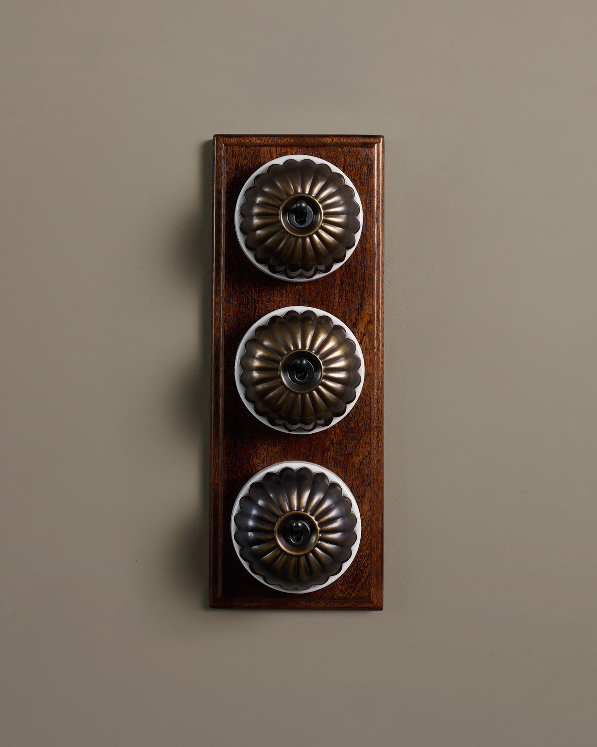 The Jelly Toggle Switch (3 Gang & Mahogany Finish Pattress) - Oxidised Brass with White Base. TEST