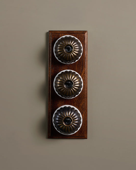 The Jelly Toggle Switch (3 Gang & Mahogany Finish Pattress) - Oxidised Brass with White Base.
