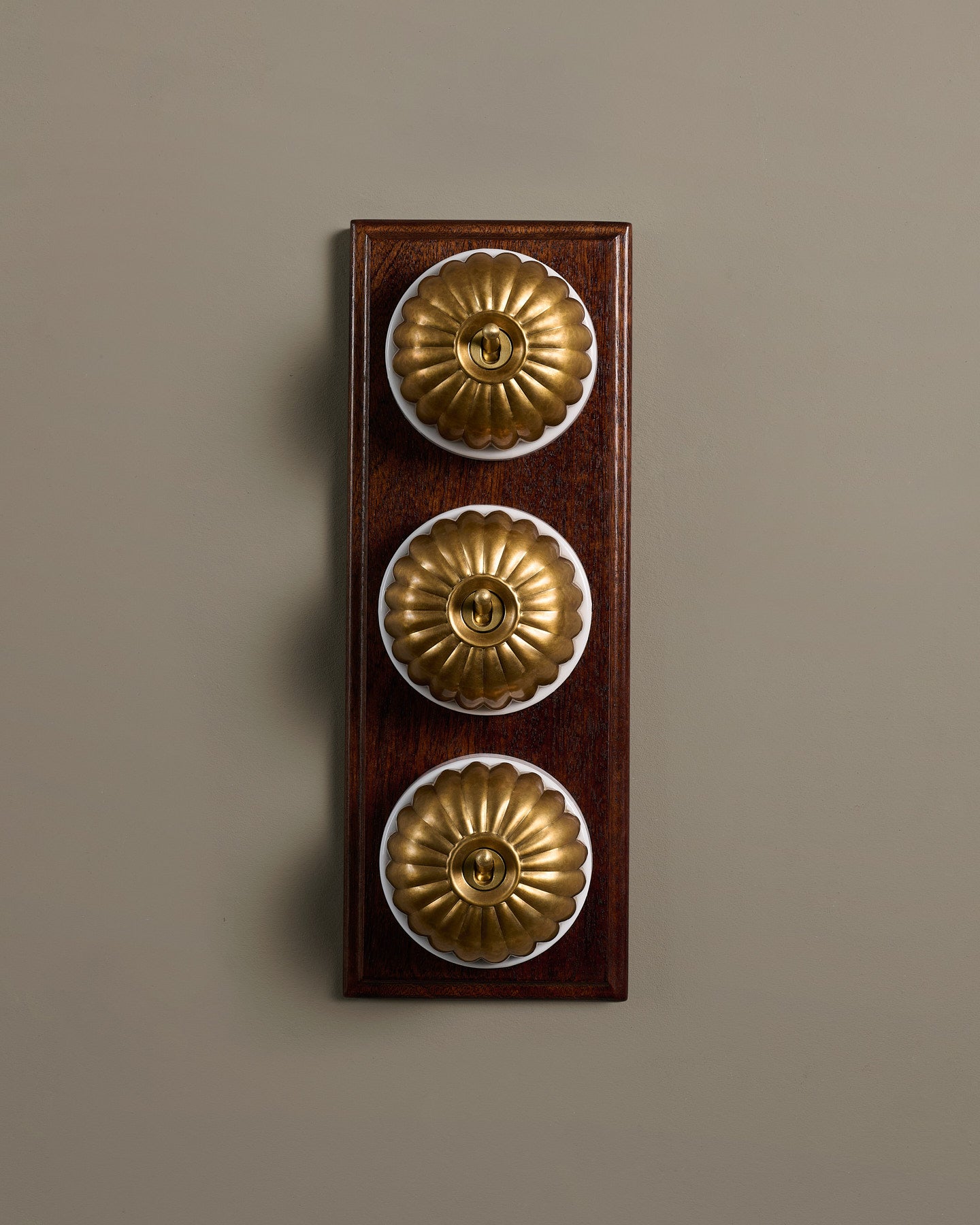 The Jelly Toggle Switch (3 Gang & Mahogany Finish Pattress) - Aged Brass with White Base.
