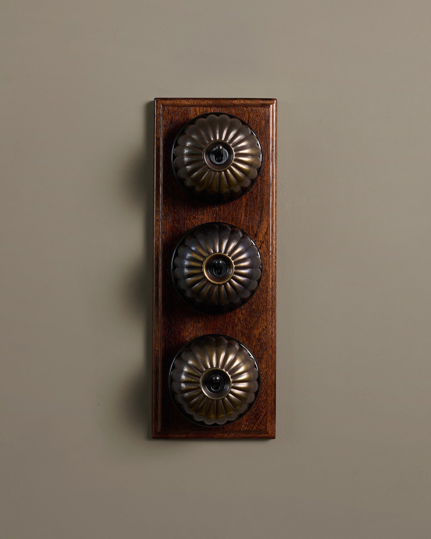 The Jelly Toggle Switch (3 Gang & Mahogany Finish Pattress) - Oxidised Brass with Black Base.
