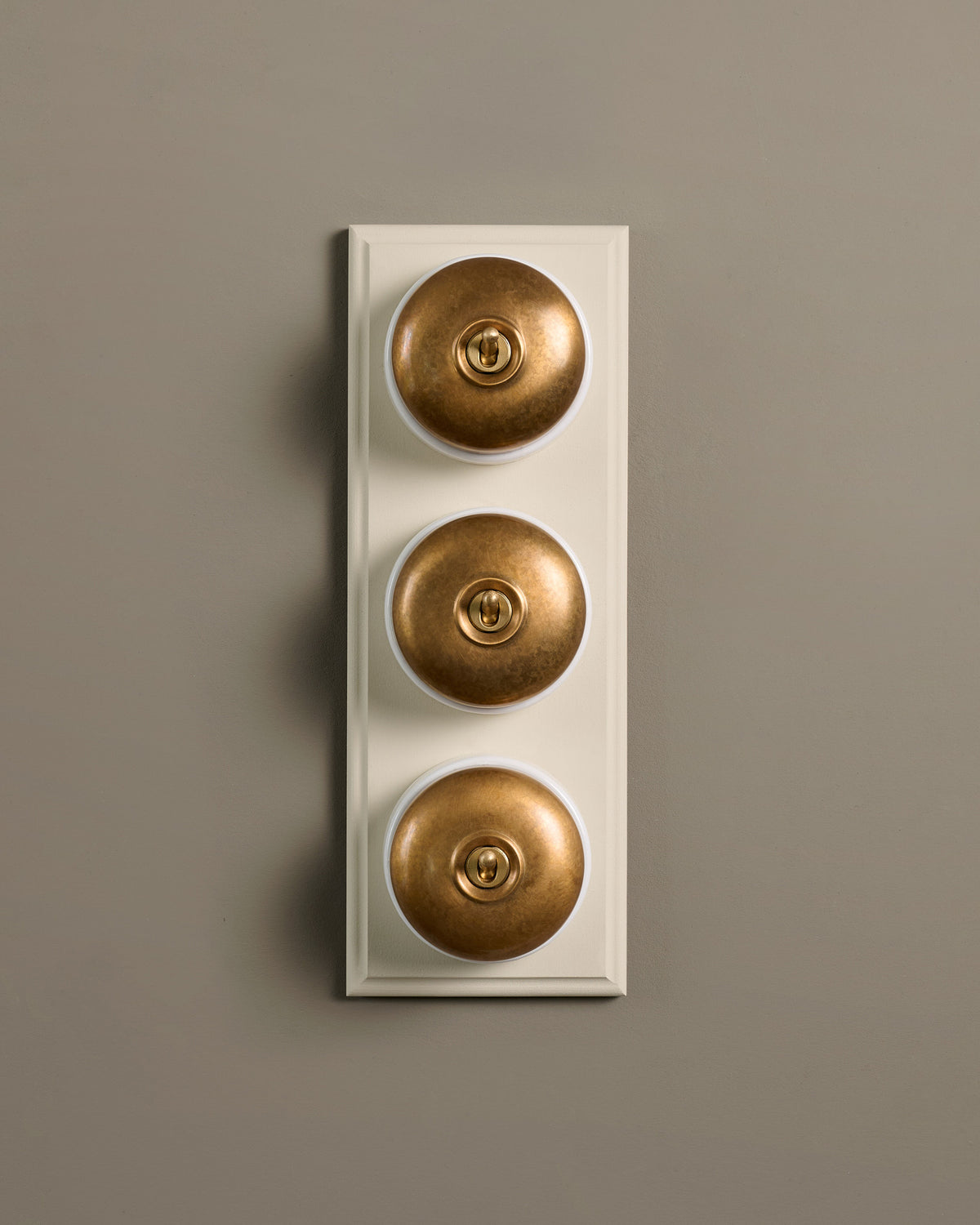 The Dolly Toggle Switch (3 Gang & Primed Maple Pattress) - Aged Brass with White Base. TEST