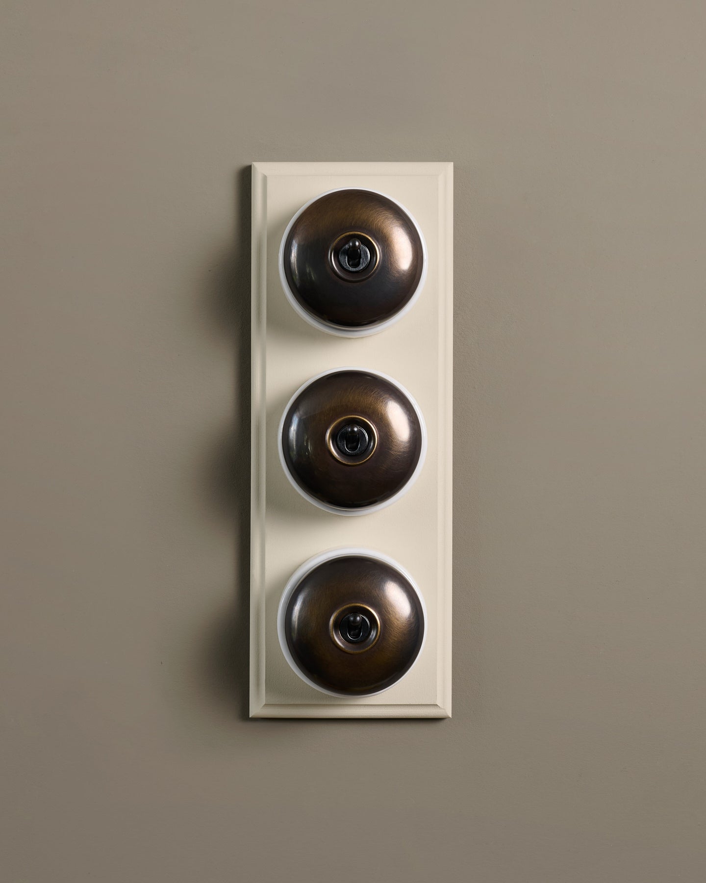 The Dolly Toggle Switch (3 Gang & Primed Maple Pattress) - Oxidised Brass with White Base.