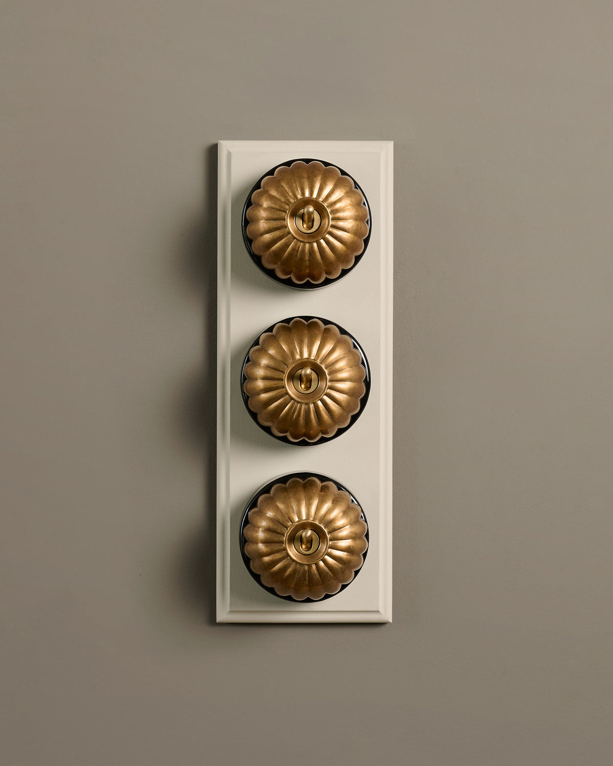 The Jelly Toggle Switch (3 Gang & Primed Maple Pattress) - Aged Brass with Black Base. TEST