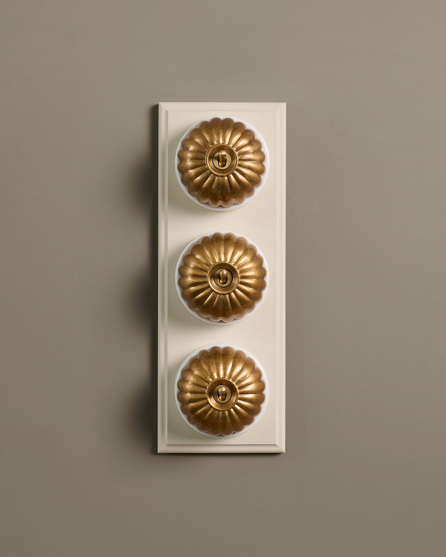 The Jelly Toggle Switch (3 Gang & Primed Maple Pattress) - Aged Brass with White Base.