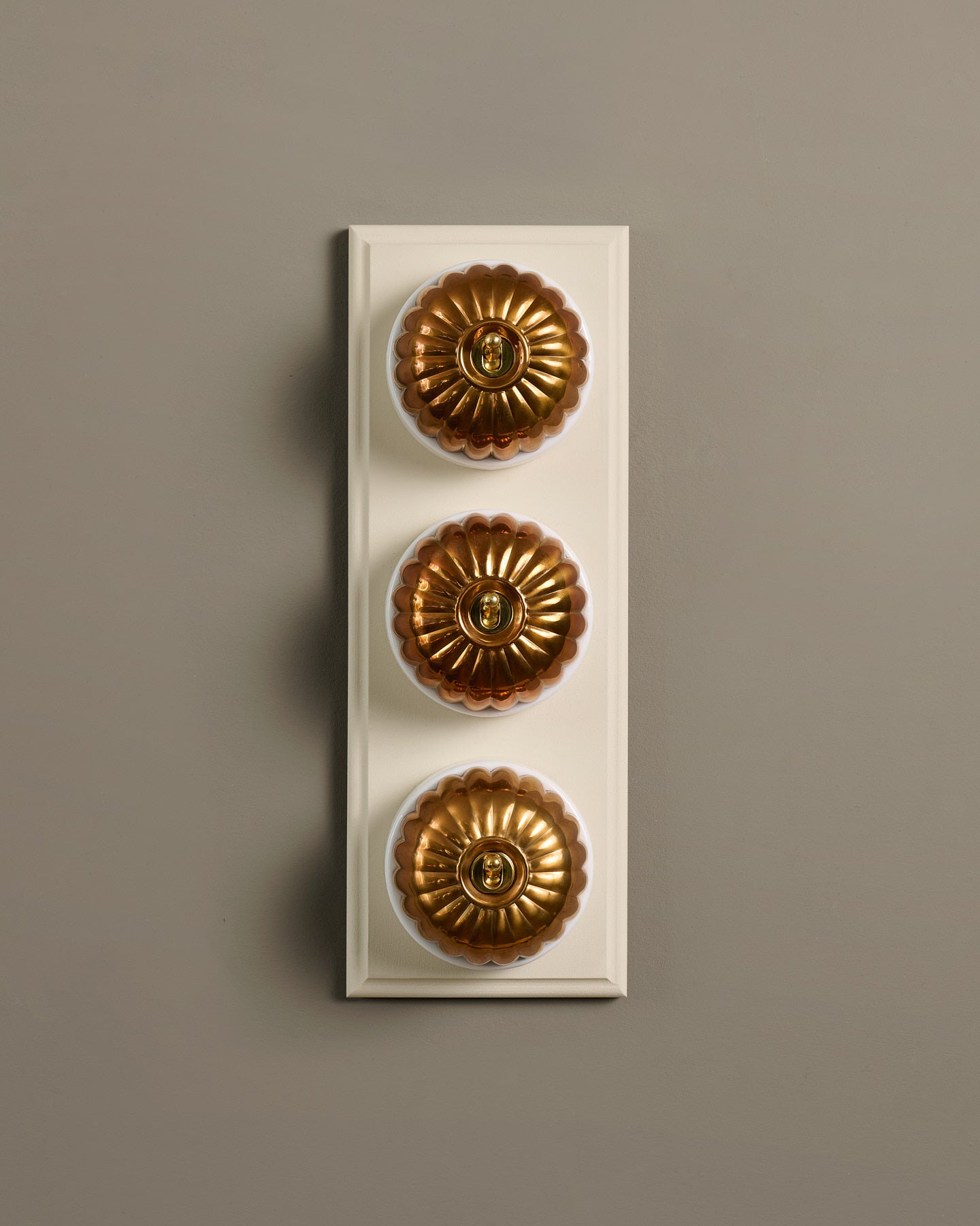 The Jelly Toggle Switch (3 Gang & Primed Maple Pattress) - Heirloom Brass with White Base.