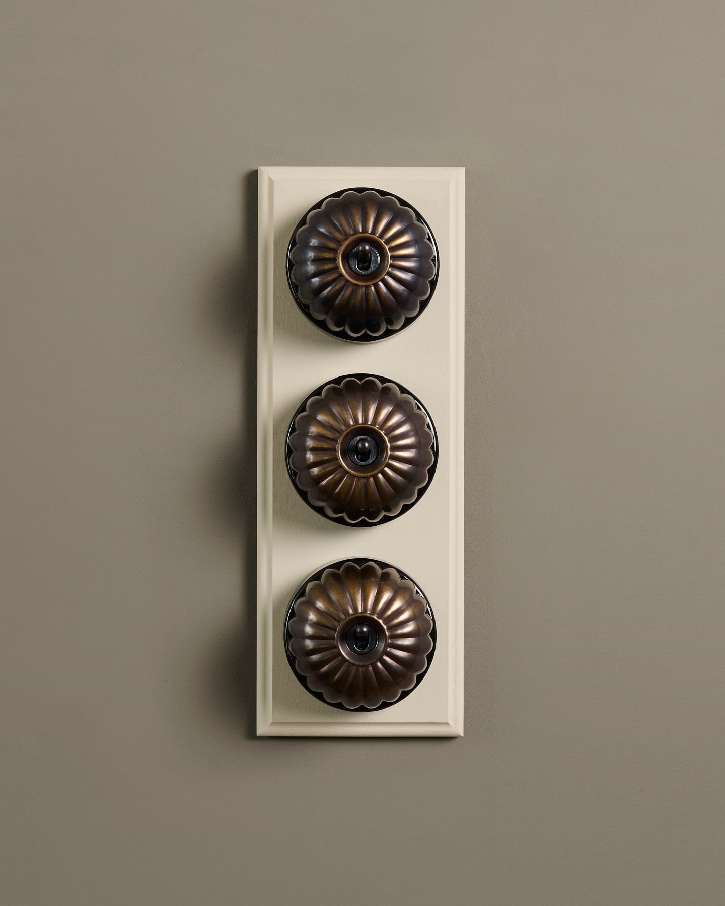 The Jelly Toggle Switch (3 Gang & Primed Maple Pattress) - Oxidised Brass with Black Base.