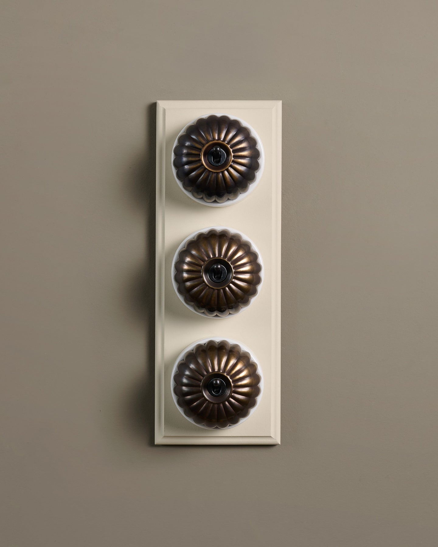 The Jelly Toggle Switch (3 Gang & Primed Maple Pattress) - Oxidised Brass with White Base.