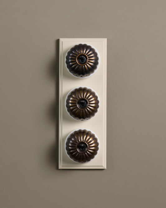 The Jelly Toggle Switch (3 Gang & Primed Maple Pattress) - Oxidised Brass with White Base.