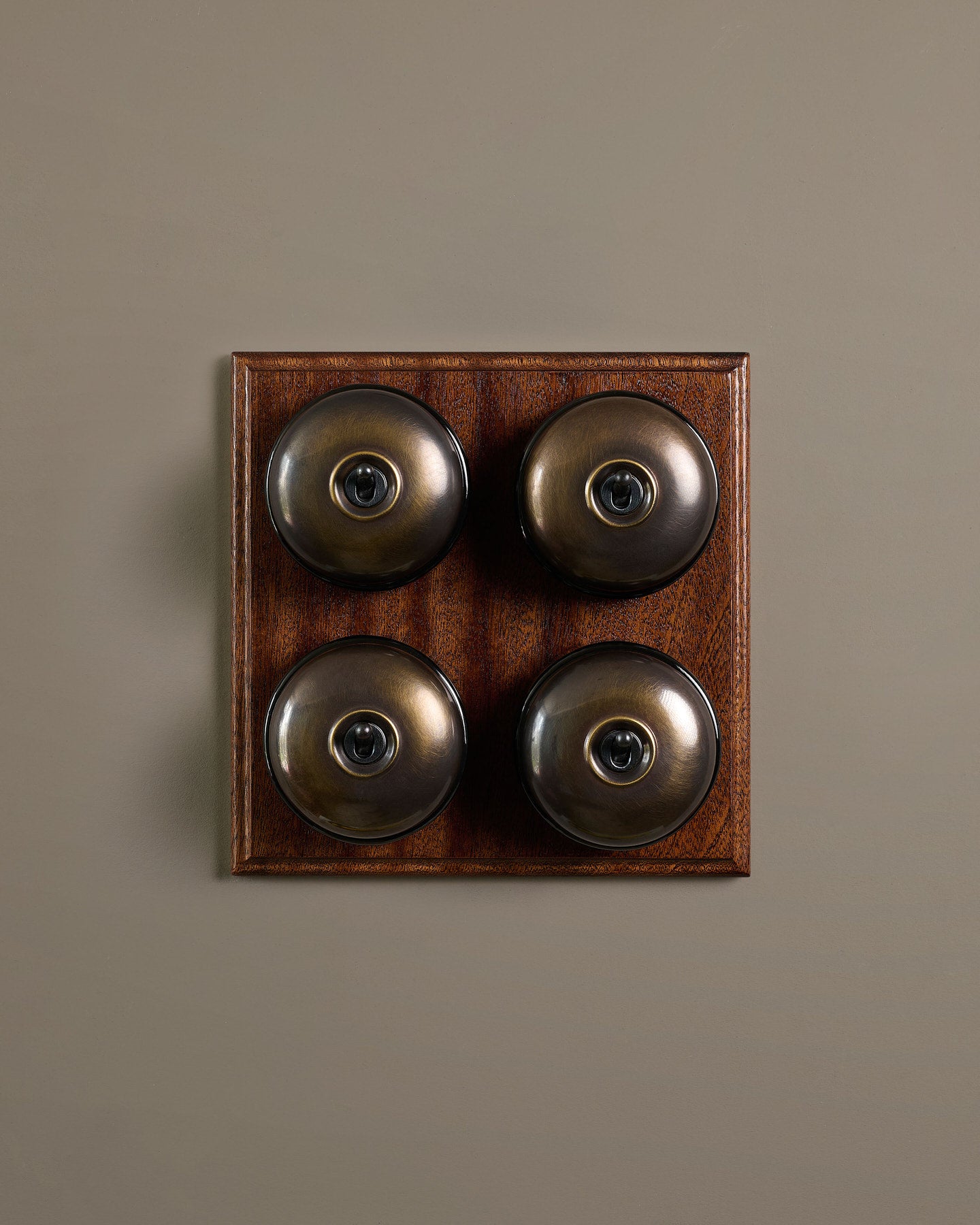 The Dolly Toggle Switch (4 Gang Bank & Mahogany Finish Pattress) - Oxidised Brass with Black Base.