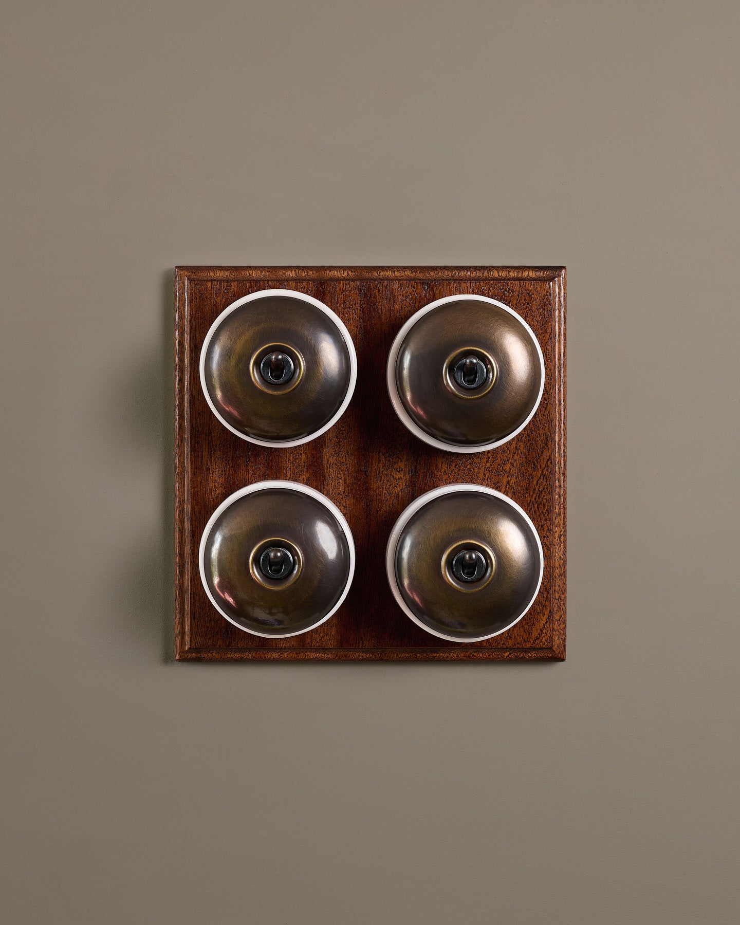 The Dolly Toggle Switch (4 Gang Bank & Mahogany Finish Pattress) - Oxidised Brass with White Base.