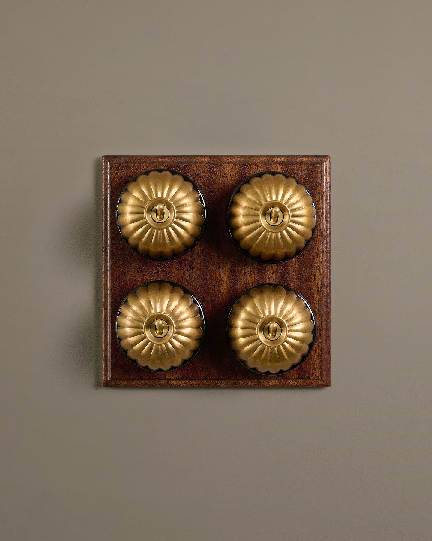 The Jelly Toggle Switch (4 Gang Bank & Mahogany Finish Pattress) - Aged Brass with Black Base.