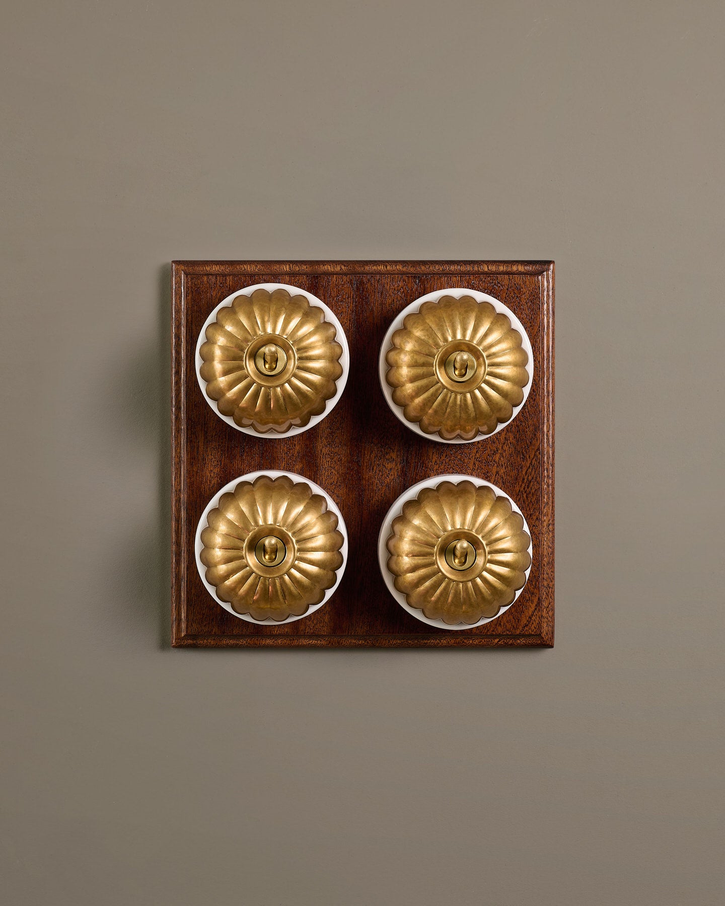 The Jelly Toggle Switch (4 Gang Bank & Mahogany Finish Pattress) - Aged Brass with White Base.