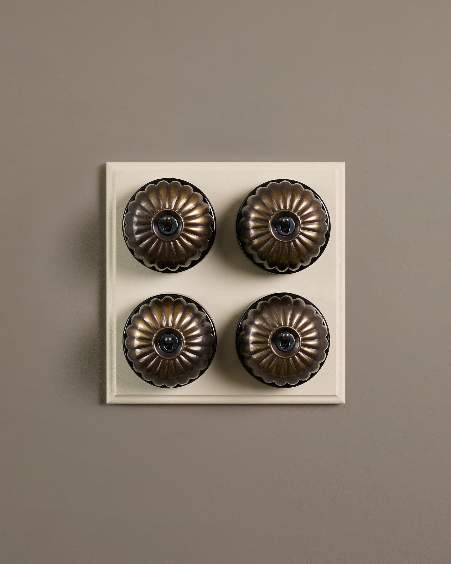 The Jelly Toggle Switch (4 Gang Bank & Primed Maple Pattress) - Oxidised Brass with Black Base.