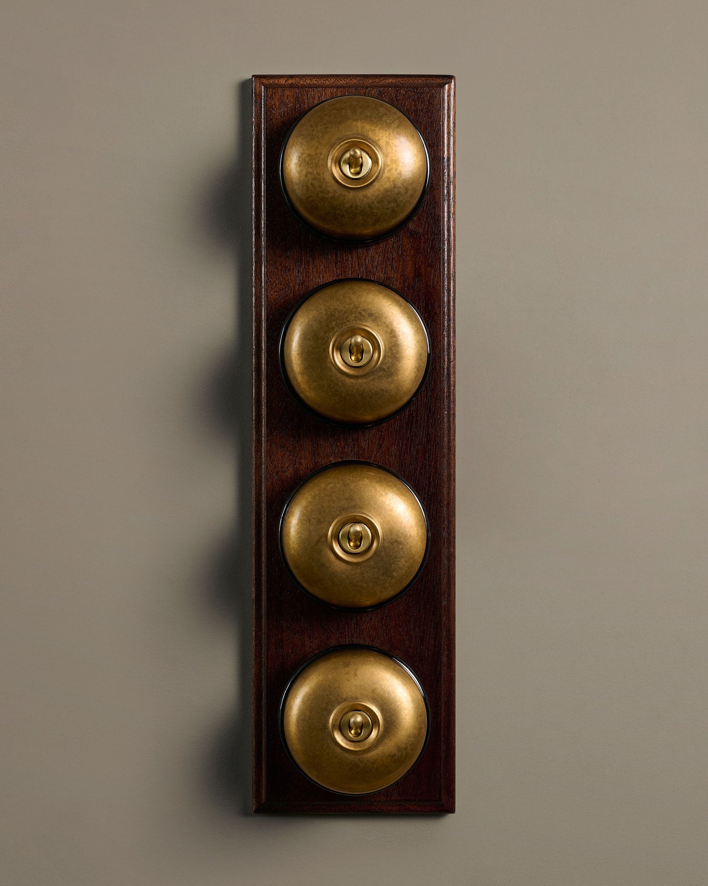 The Dolly Toggle Switch (4 Gang Row & Mahogany Finish Pattress) - Aged Brass with Black Base.