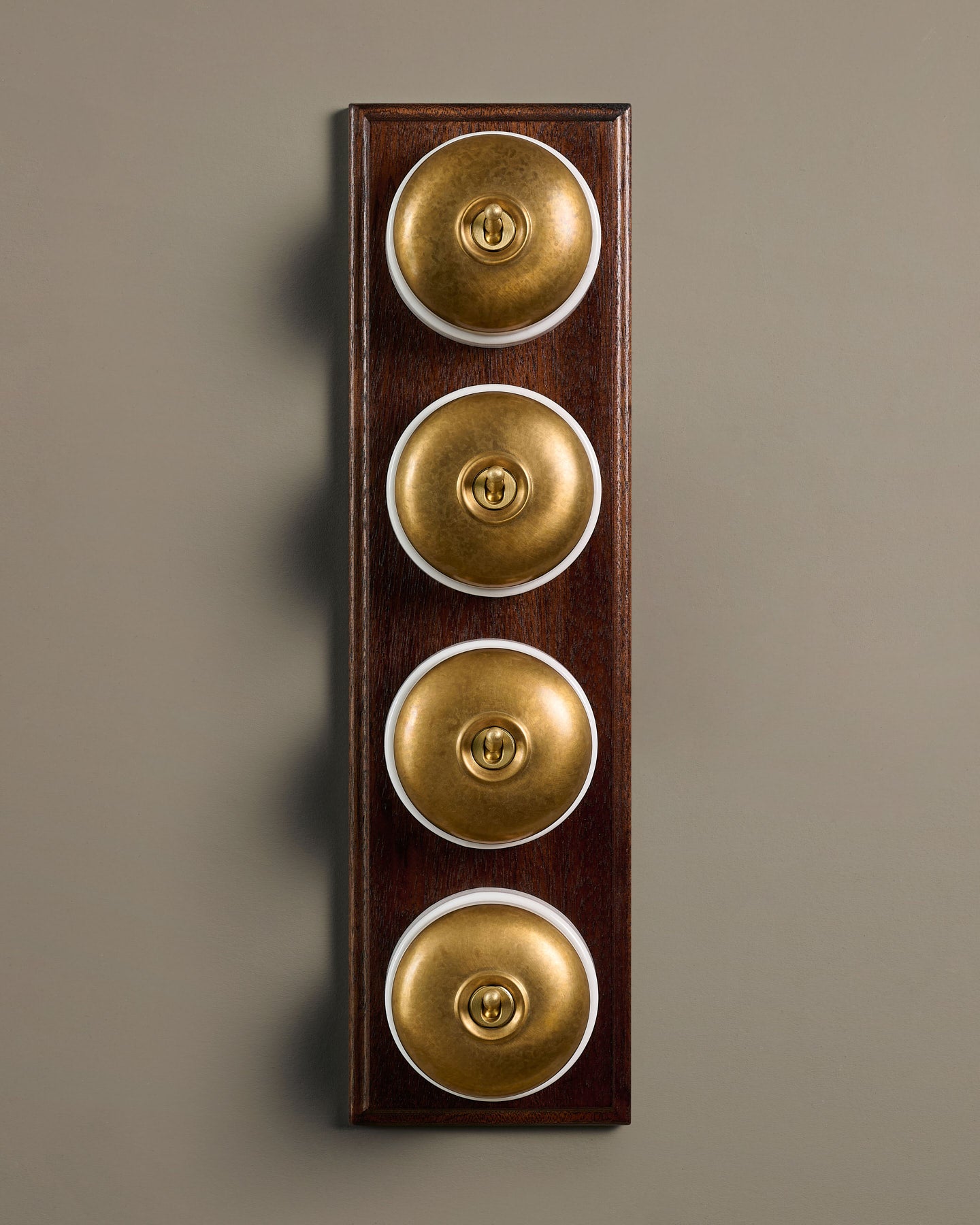 The Dolly Toggle Switch (4 Gang Row & Mahogany Finish Pattress) - Aged Brass with White Base.