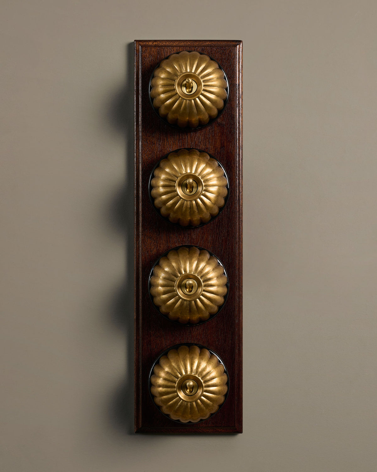 The Jelly Toggle Switch (4 Gang Row & Mahogany Finish Pattress) - Aged Brass with Black Base. TEST
