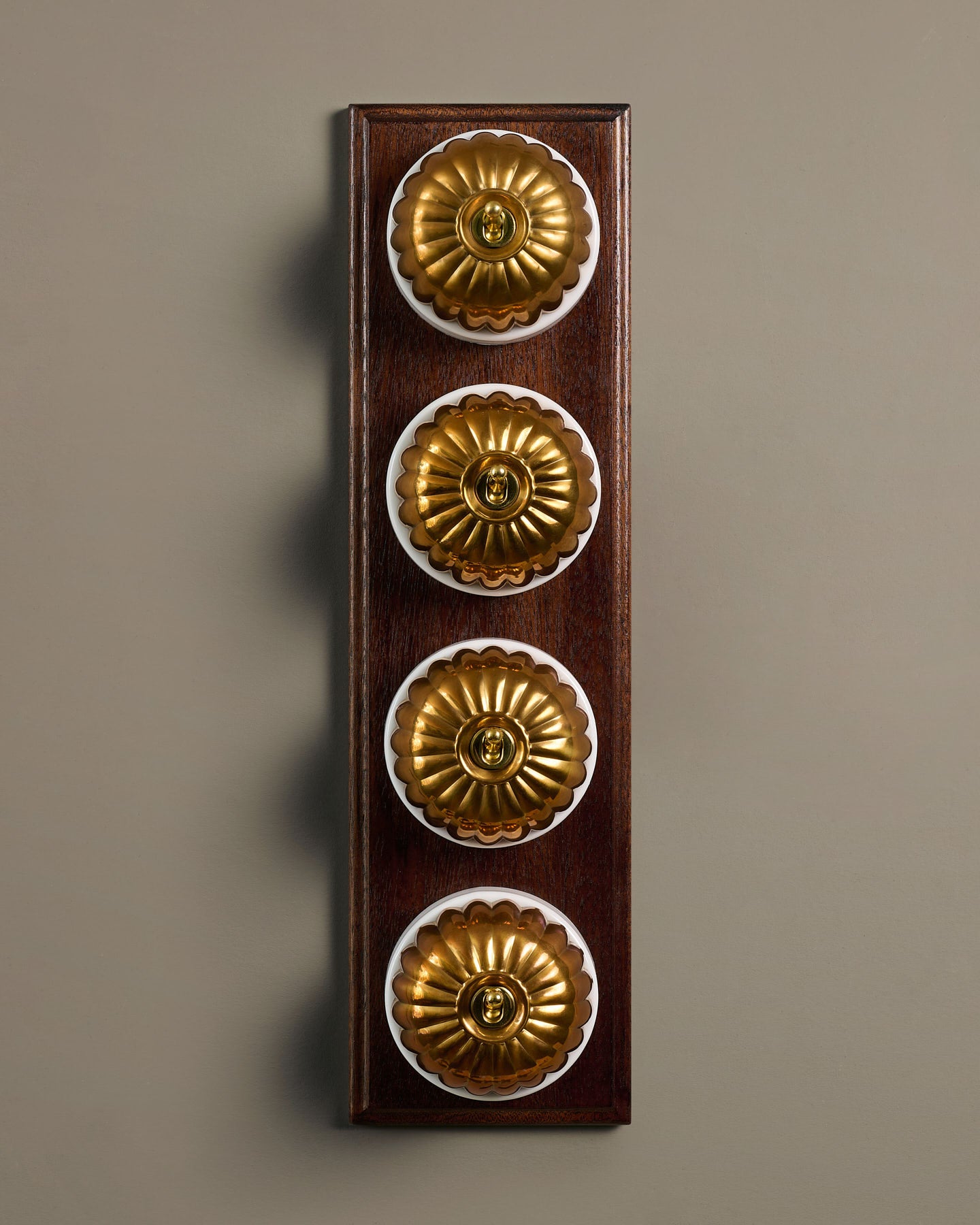 The Jelly Toggle Switch (4 Gang Row & Mahogany Finish Pattress) - Heirloom Brass with White Base.