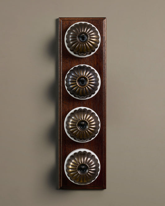 The Jelly Toggle Switch (4 Gang Row & Mahogany Finish Pattress) - Oxidised Brass with White Base.