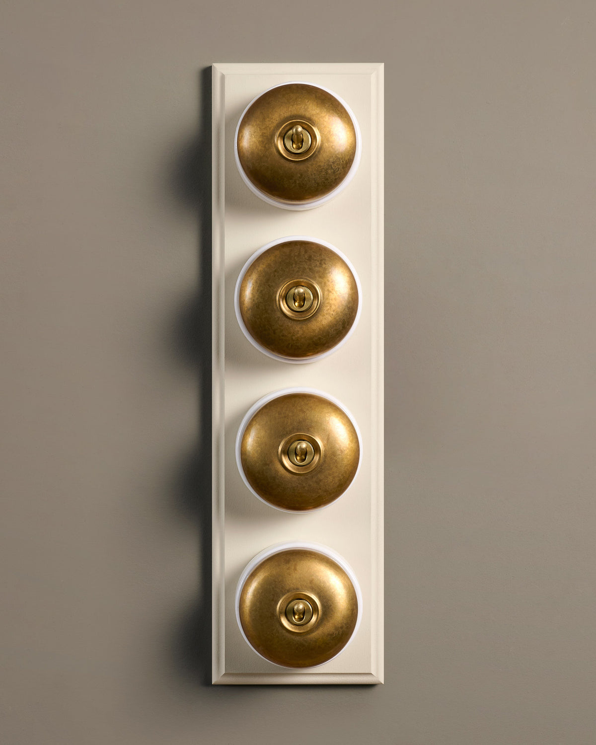 The Dolly Toggle Switch (4 Gang Row & Primed Maple Pattress) - Aged Brass with White Base. TEST