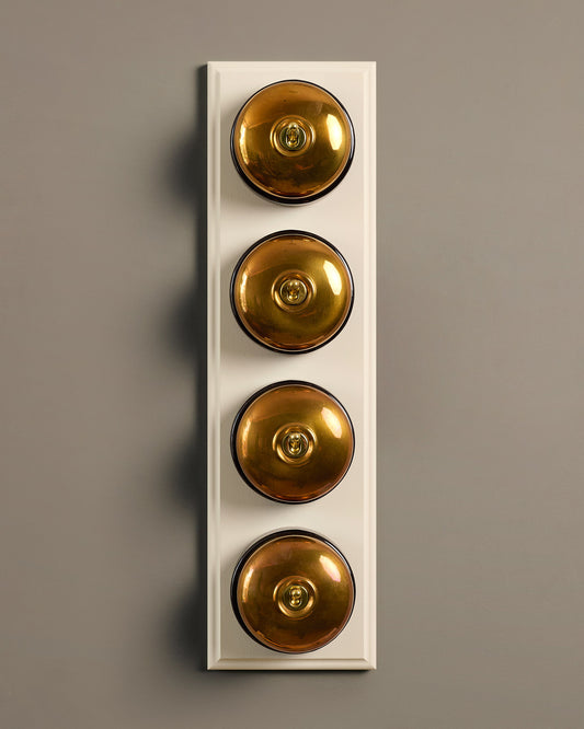 The Dolly Toggle Switch (4 Gang Row & Primed Maple Pattress) - Heirloom Brass with Black Base.