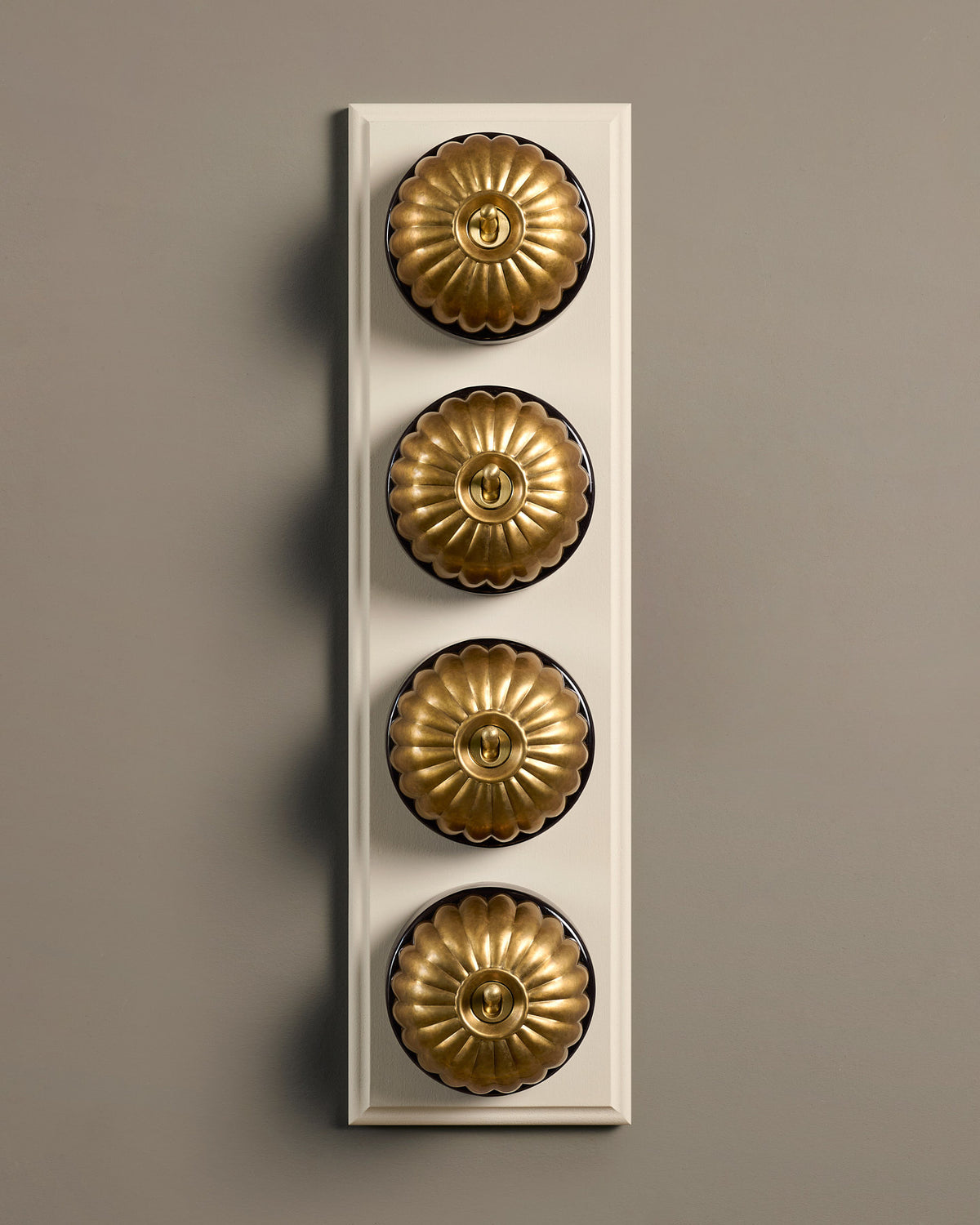 The Jelly Toggle Switch (4 Gang Row & Primed Maple Pattress) - Aged Brass with Black Base. TEST