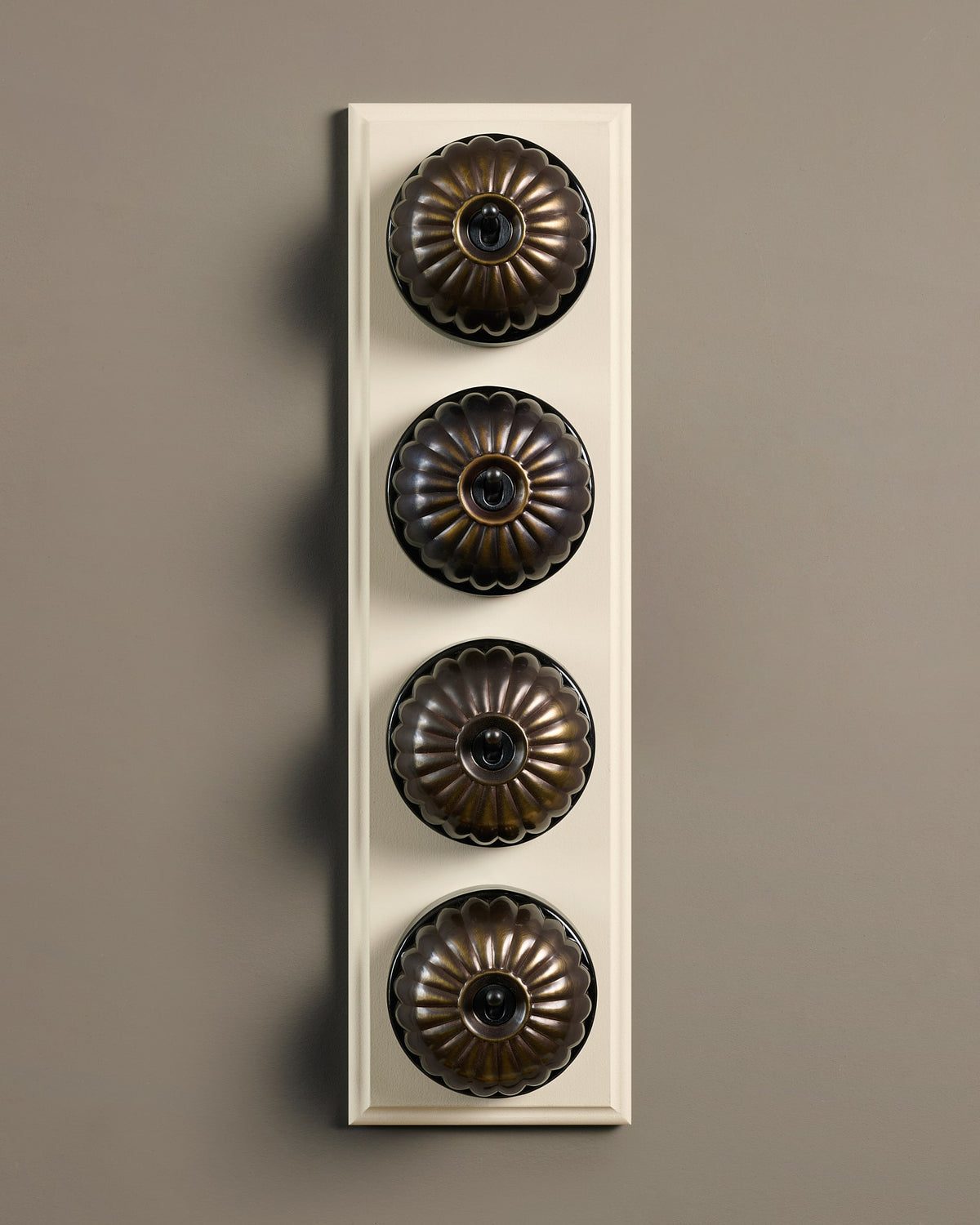 The Jelly Toggle Switch (4 Gang Row & Primed Maple Pattress) - Oxidised Brass with Black Base. TEST