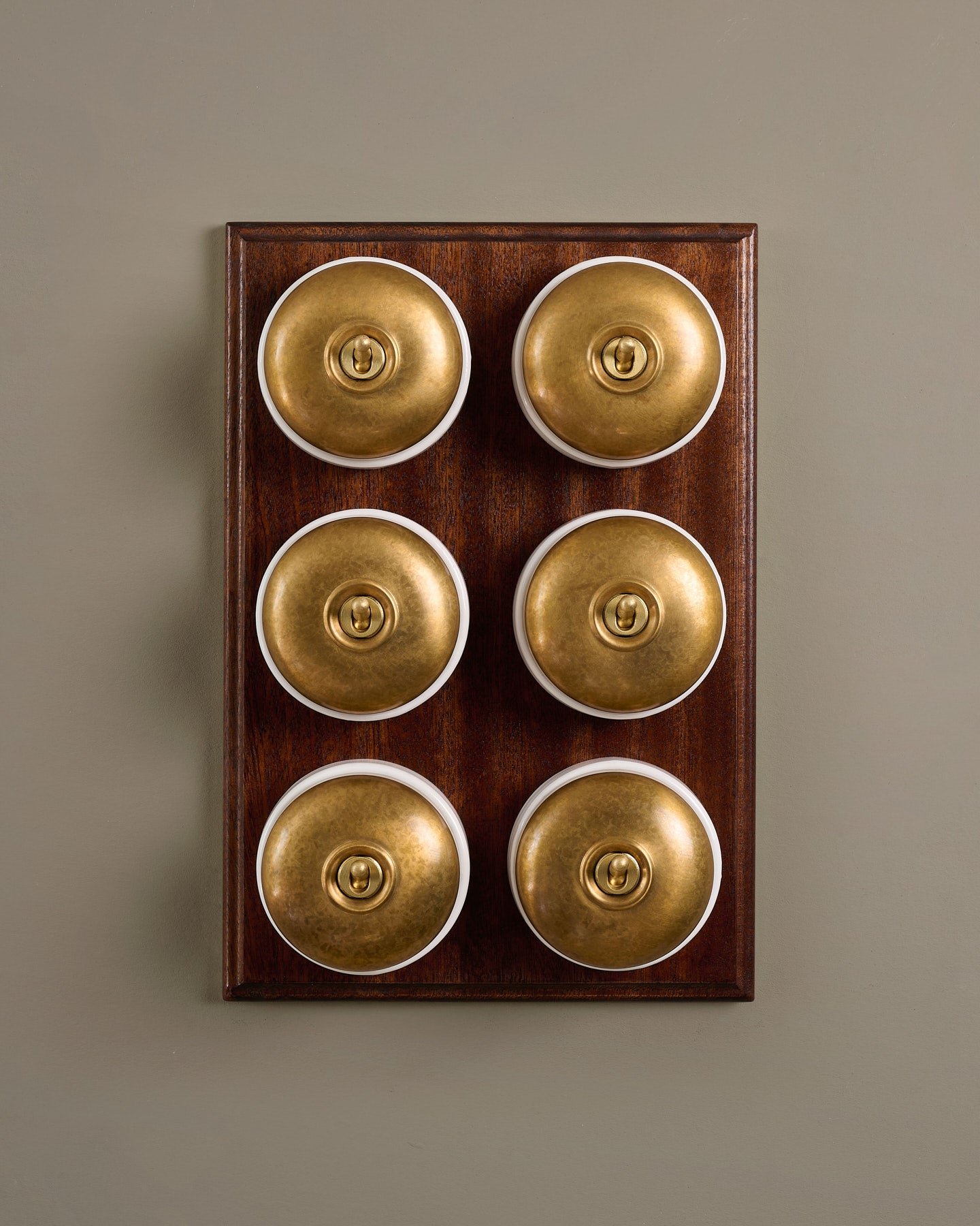 The Dolly Toggle Switch (6 Gang & Mahogany Finish Pattress) - Aged Brass with White Base.