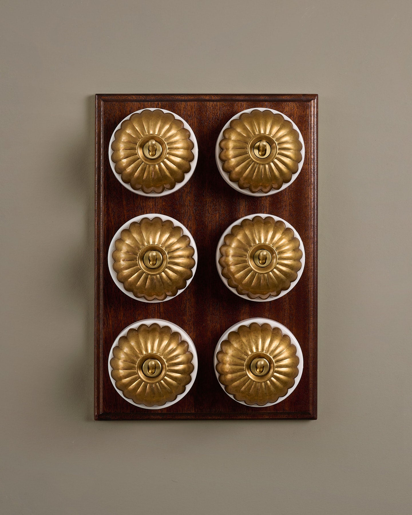 The Jelly Toggle Switch (6 Gang & Mahogany Finish Pattress) - Aged Brass with White Base.