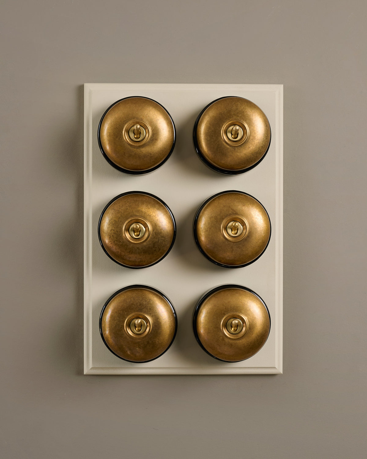 The Dolly Toggle Switch (6 Gang & Primed Maple Pattress) - Aged Brass with Black Base. TEST