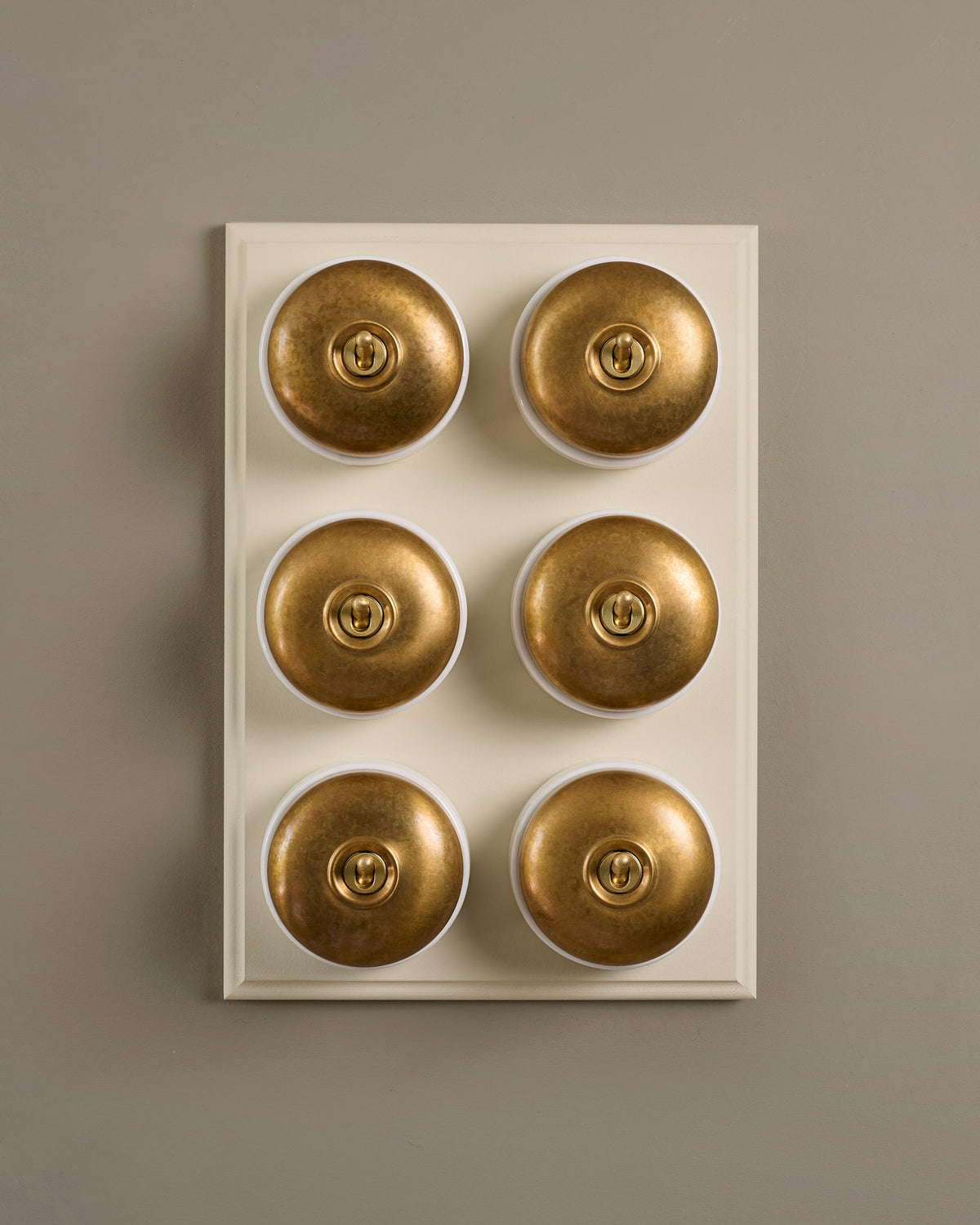 The Dolly Toggle Switch (6 Gang & Primed Maple Pattress) - Aged Brass with White Base. TEST