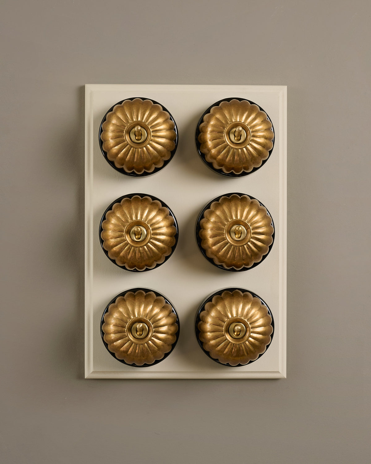 The Jelly Toggle Switch (6 Gang & Primed Maple Pattress) - Aged Brass with Black Base. TEST