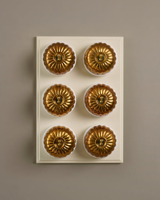 The Jelly Toggle Switch (6 Gang & Primed Maple Pattress) - Heirloom Brass with White Base.