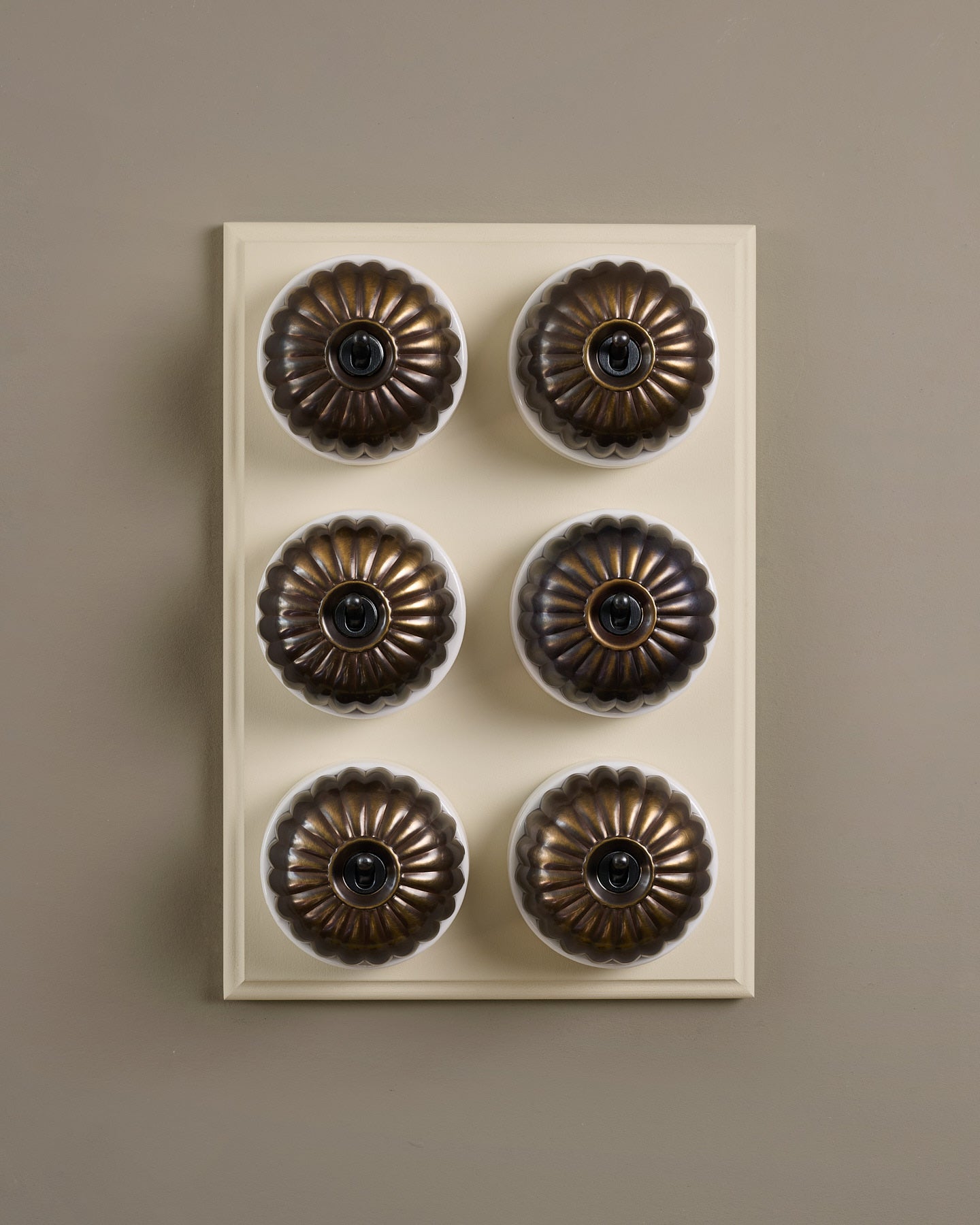 The Jelly Toggle Switch (6 Gang & Primed Maple Pattress) - Oxidised Brass with White Base.