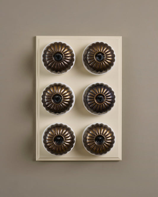 The Jelly Toggle Switch (6 Gang & Primed Maple Pattress) - Oxidised Brass with White Base.