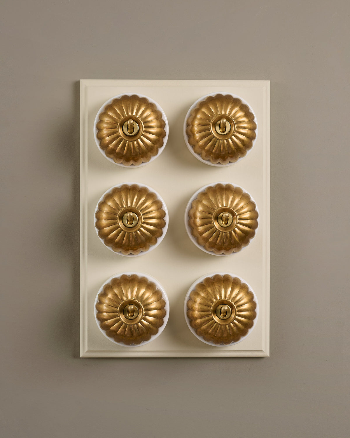 The Jelly Toggle Switch (6 Gang & Primed Maple Pattress) - Aged Brass with White Base. TEST