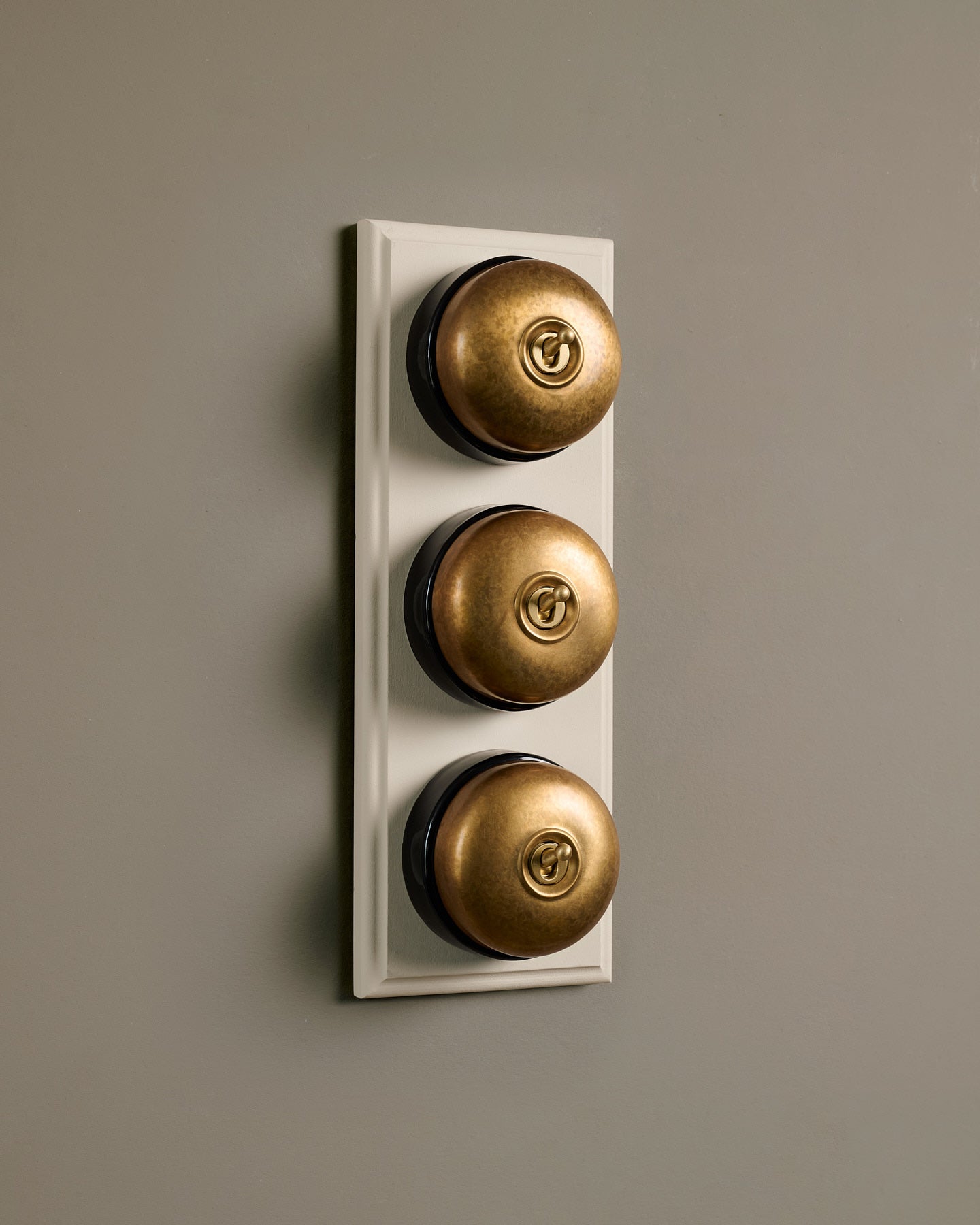The Dolly Toggle Switch (3 Gang & Primed Maple Pattress) - Aged Brass with Black Base.