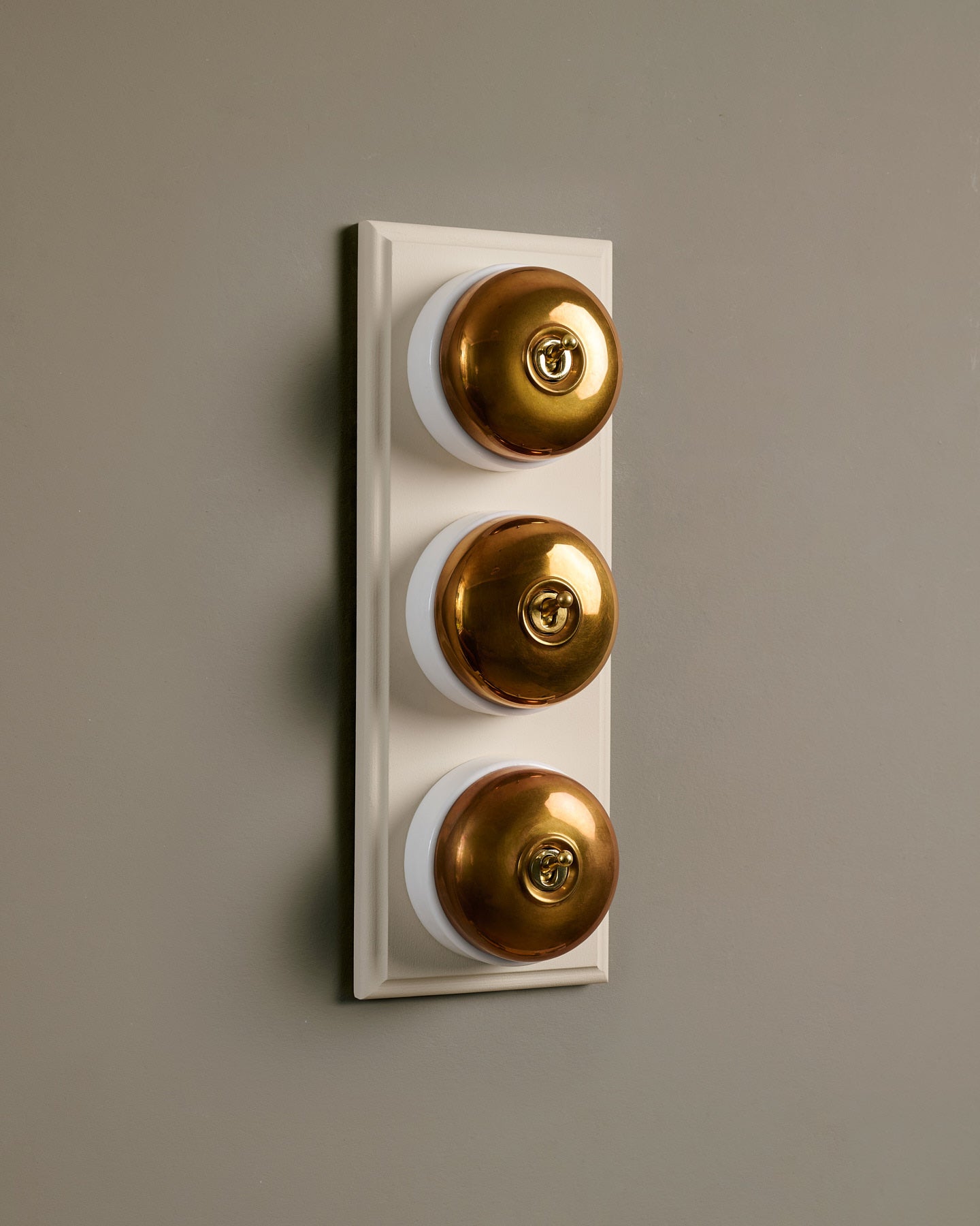 The Dolly Toggle Switch (3 Gang & Primed Maple Pattress) - Heirloom Brass with White Base.